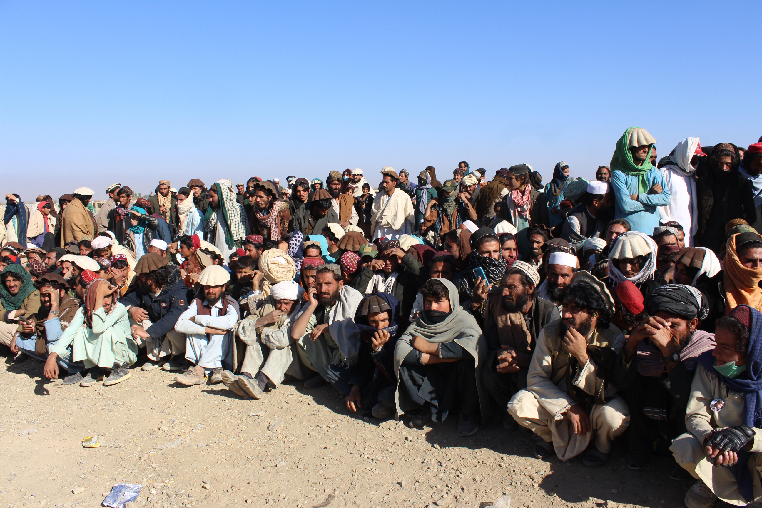 Afghans wait for aid to be distributed.