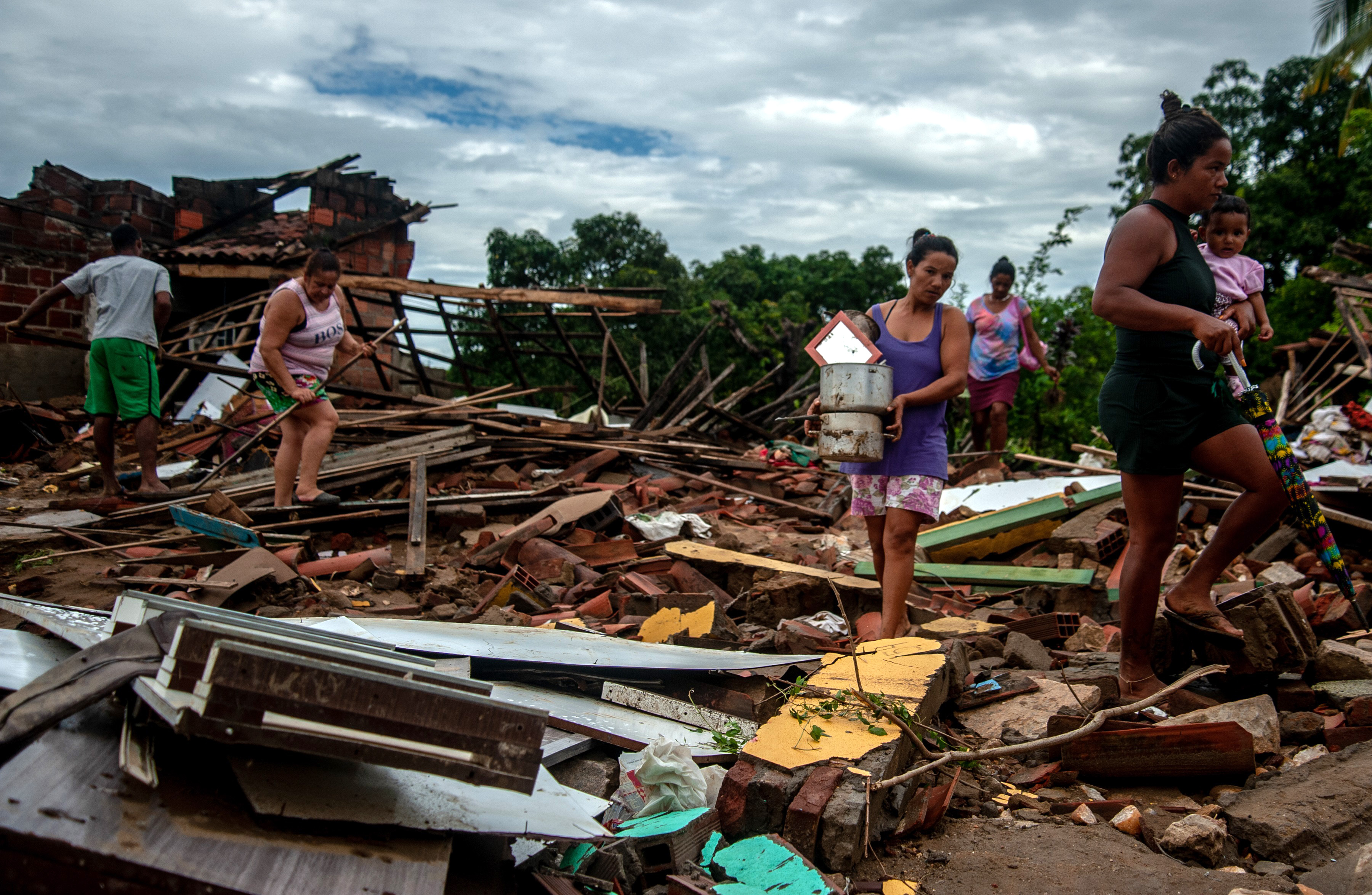 Residents clean out their flooded homes in Bahia state, Brazil