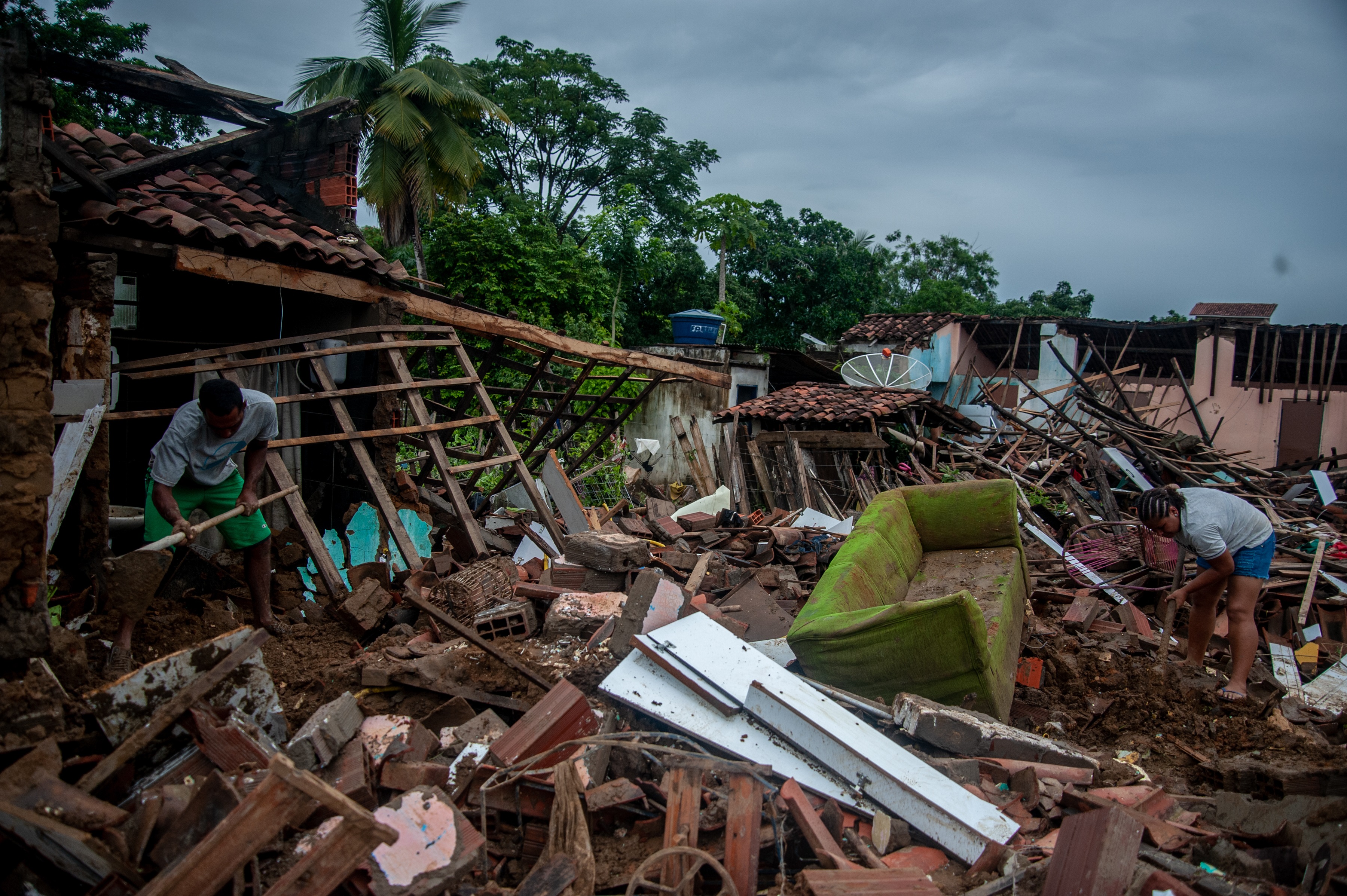 Residents clean out their flooded homes in Bahia state, Brazil