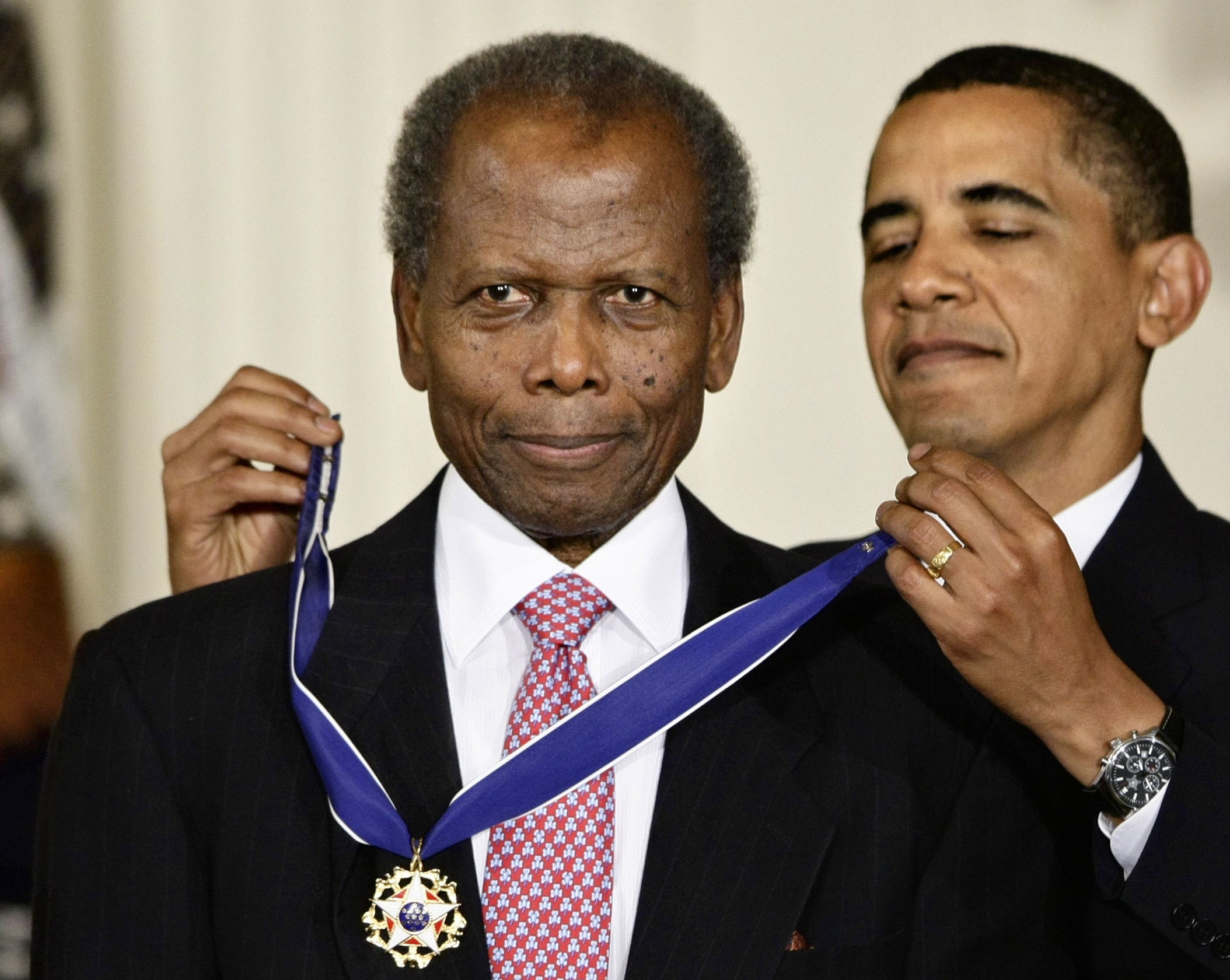 President Barack Obama putting the 2009 Presidential Medal of Freedom around Sidney Poitier's neck