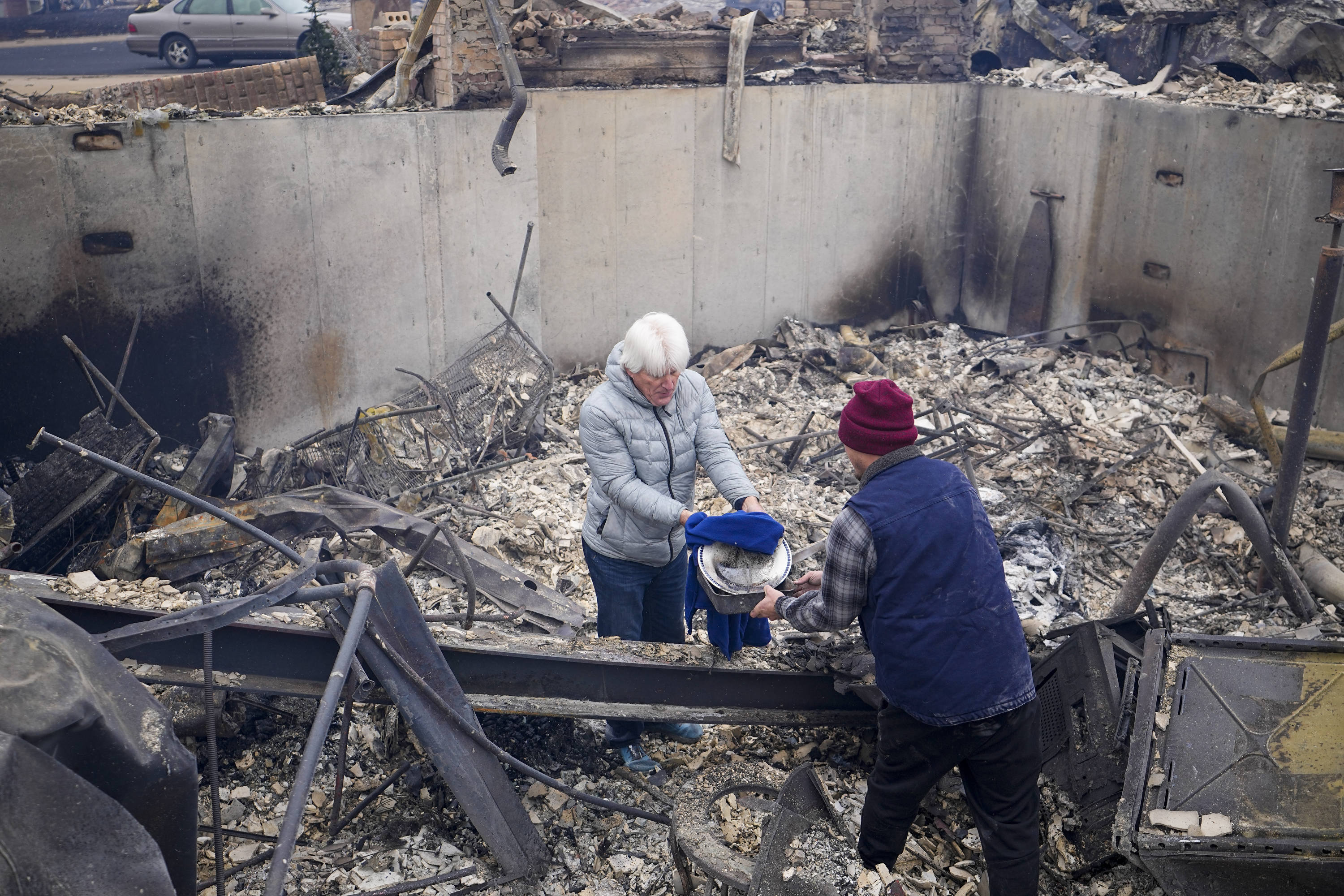 John Peer looks through the rubble of his fire-damaged home in Colorado