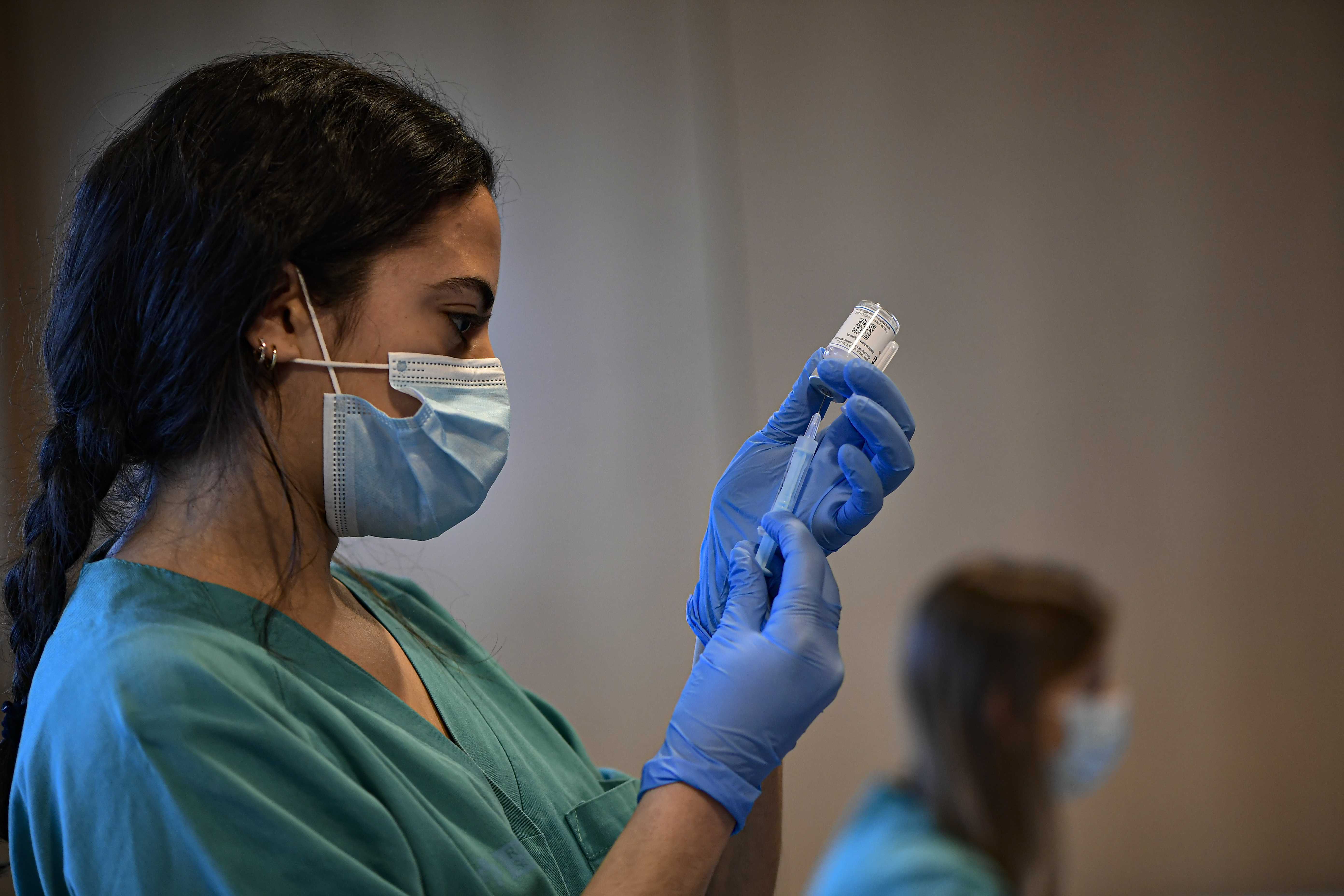A medical staff member prepares a dose of the Moderna COVID-19 vaccine, at San Pedro