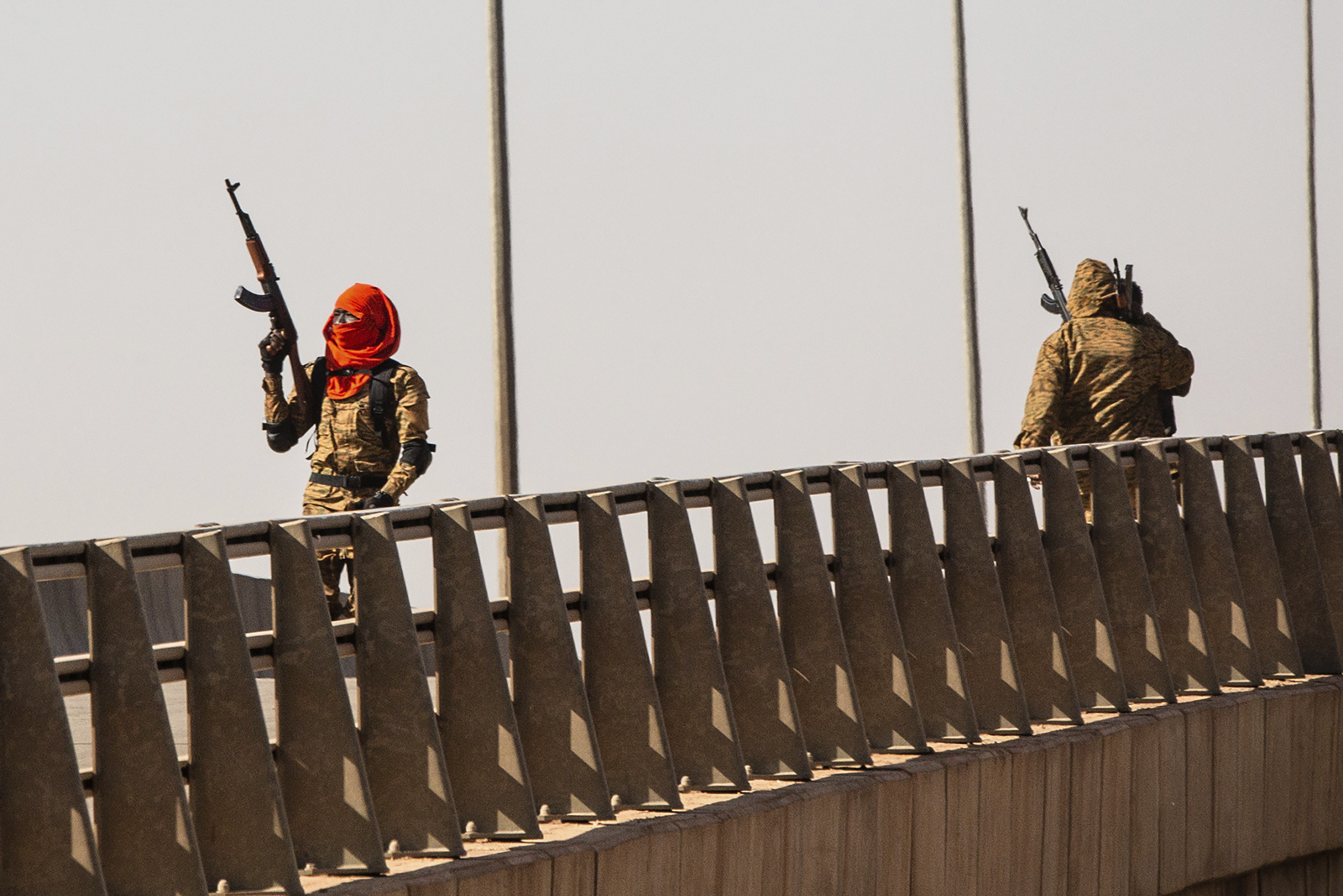 A mutinous soldier fires into the air at the Bobo interchange, near the Lamizana camp in Burkina Faso's capital Ouagadougou Sunday Jan. 23, 2022. Witnesses are reporting heavy gunfire at a military base raising fears that a coup attempt is underway. Government spokesman Alkassoum Maiga acknowledged the gunfire but denied that the military had taken over the West African country.