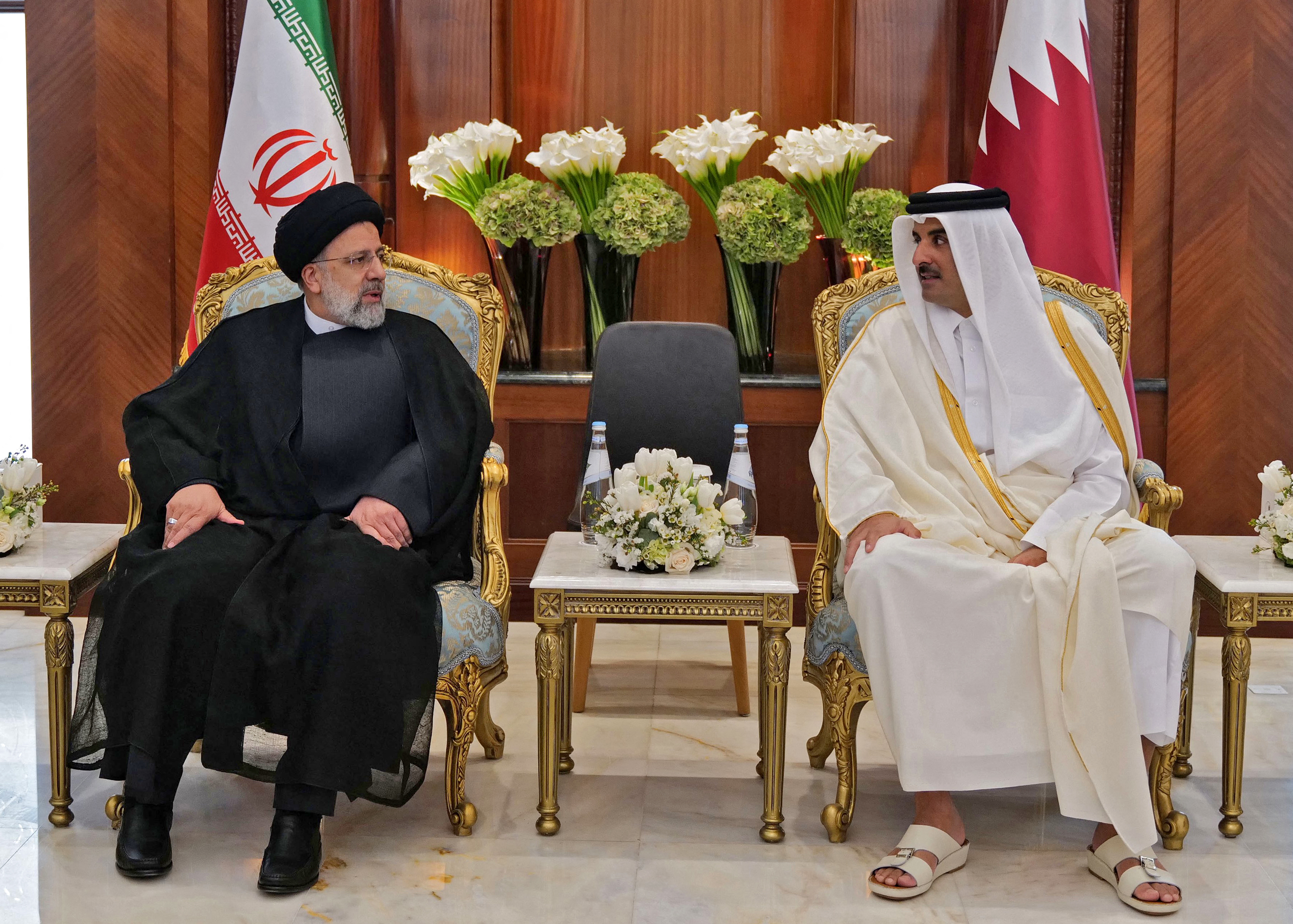 Qatar's Emir Sheikh Tamim bin Hamad al-Thani welcoming Iranian President Ebrahim Raisi (L) upon his arrival to Qatar