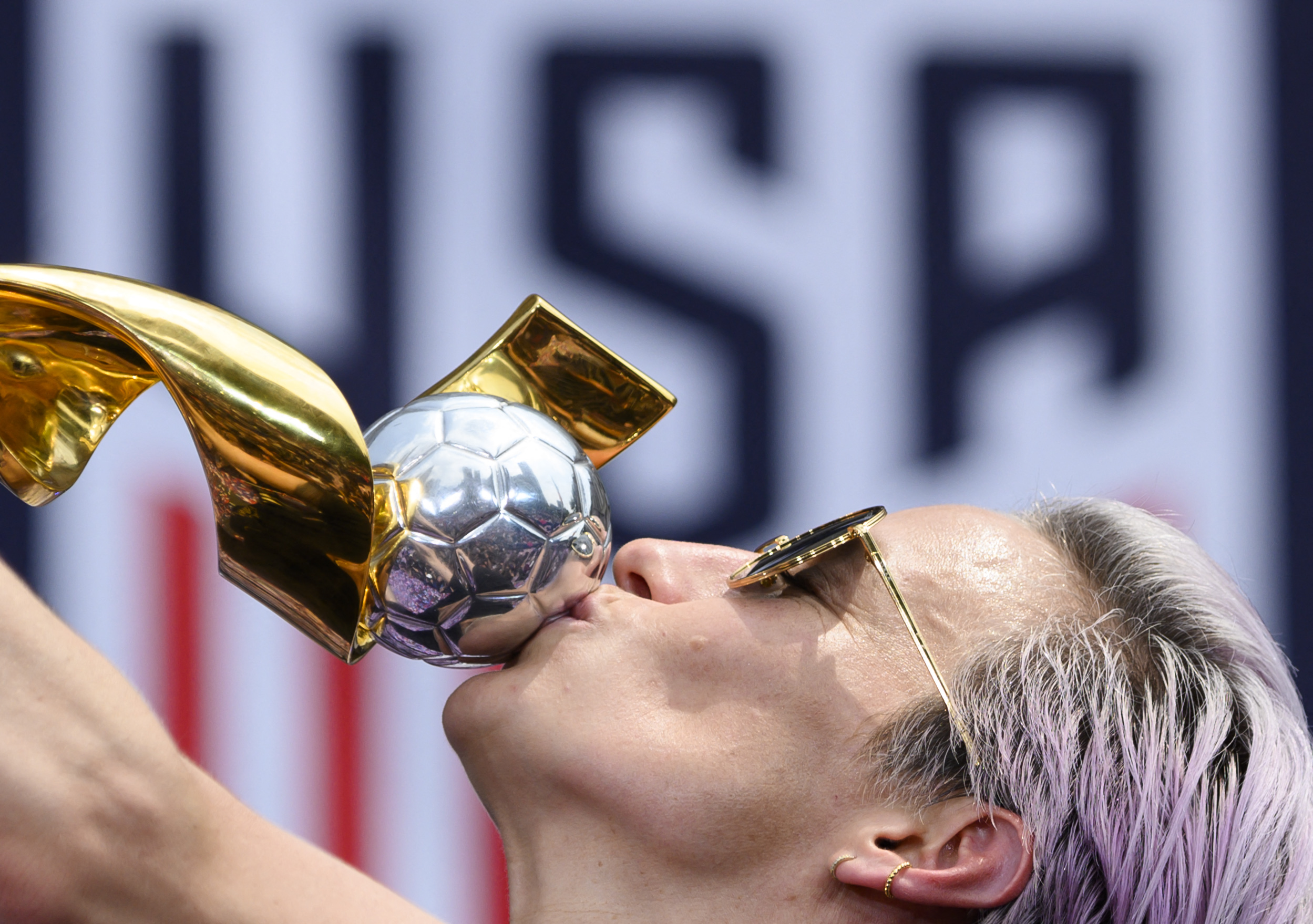 Megan Rapinoe kisses a trophy