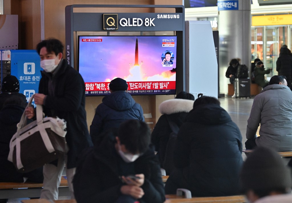 People watch a television screen showing a news broadcast with file footage of a North Korean missile test, at a railway station in Seoul.
