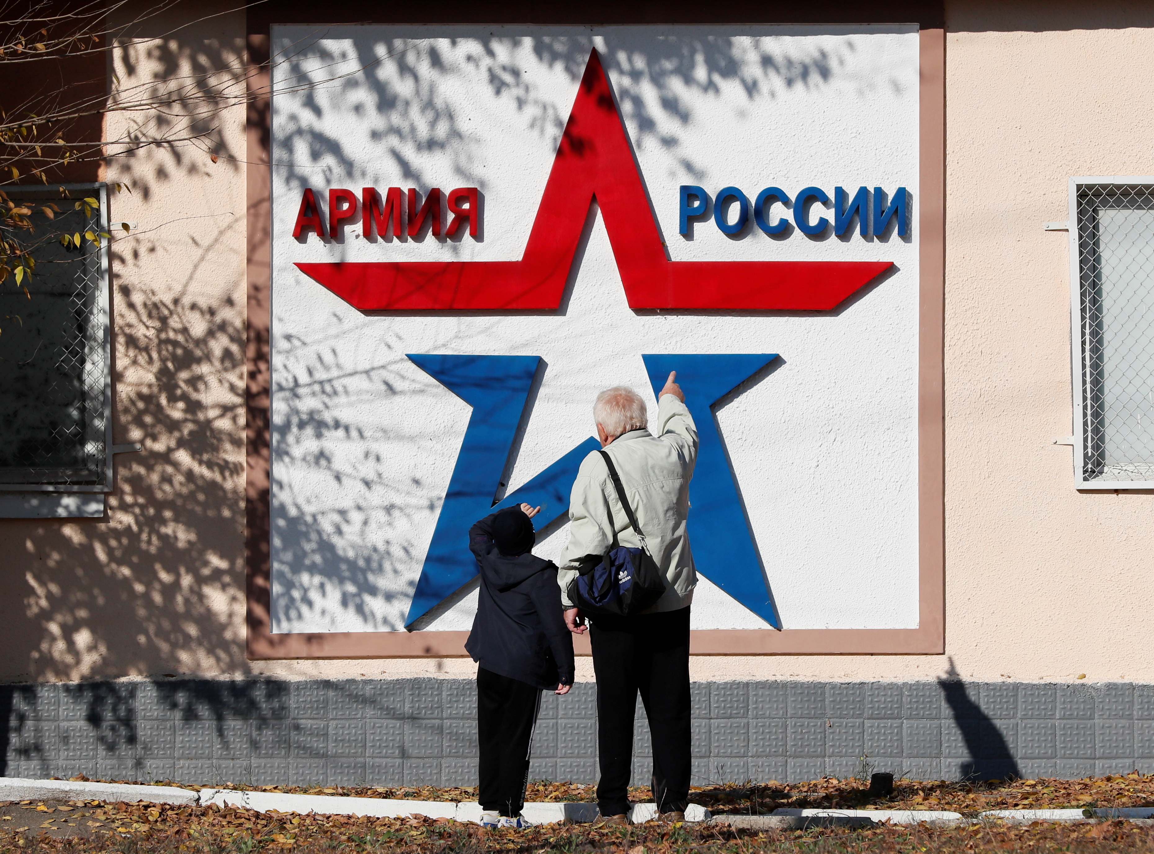 Local residents look at a banner on the Operational Group of Russian Forces headquarters in Tiraspol