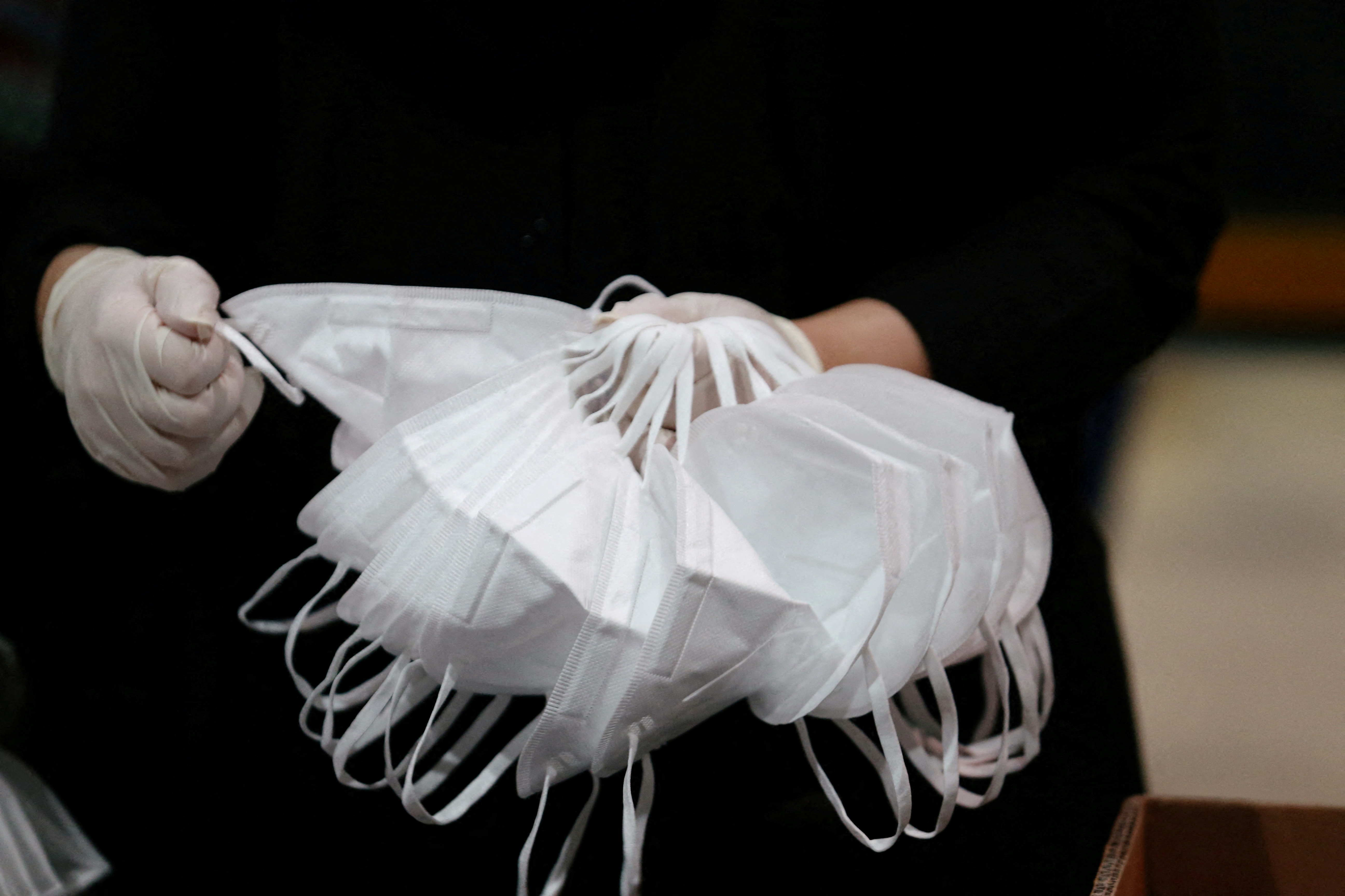 A worker sorts through a stack of N95 masks.