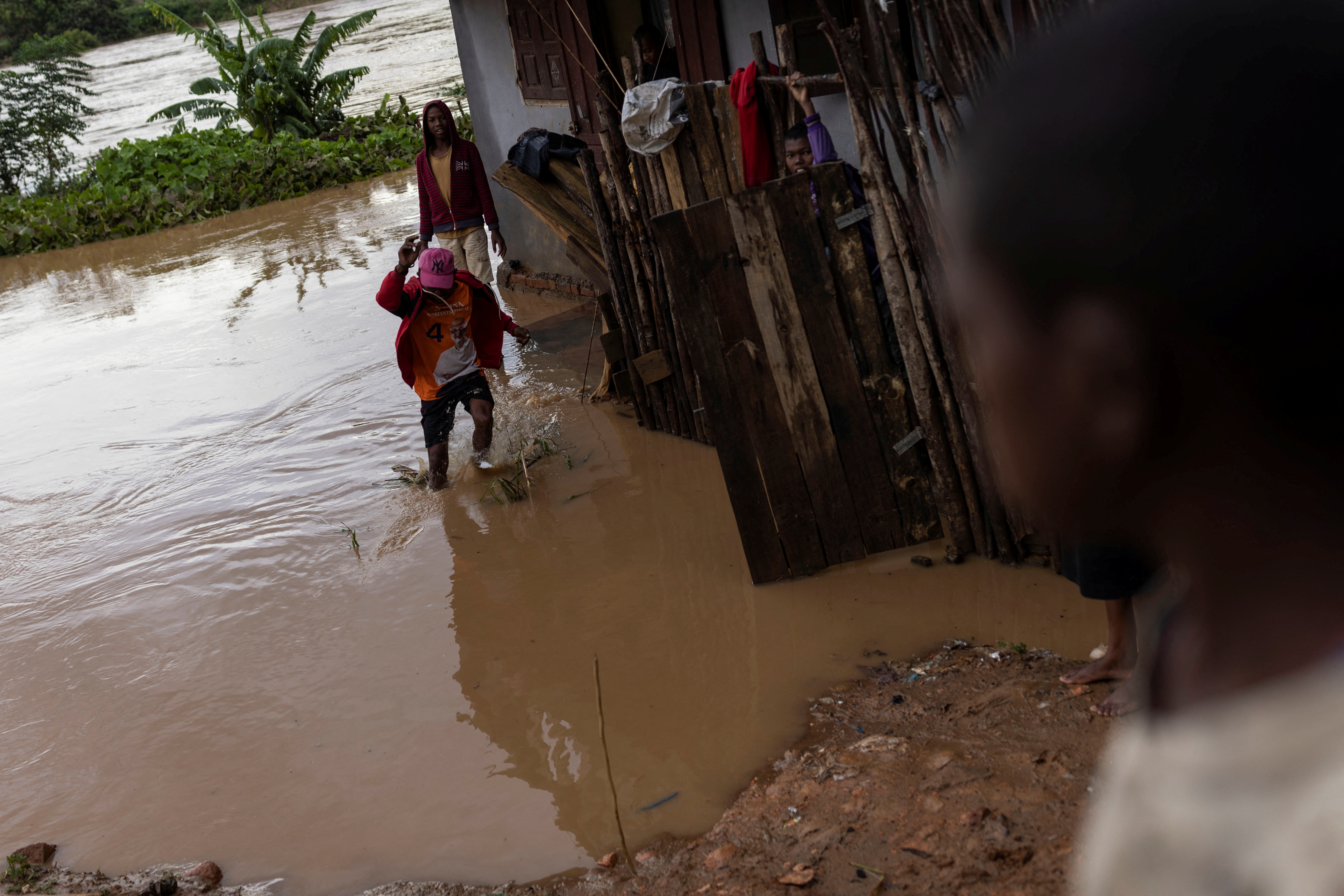 A local jumps outside his flooded house