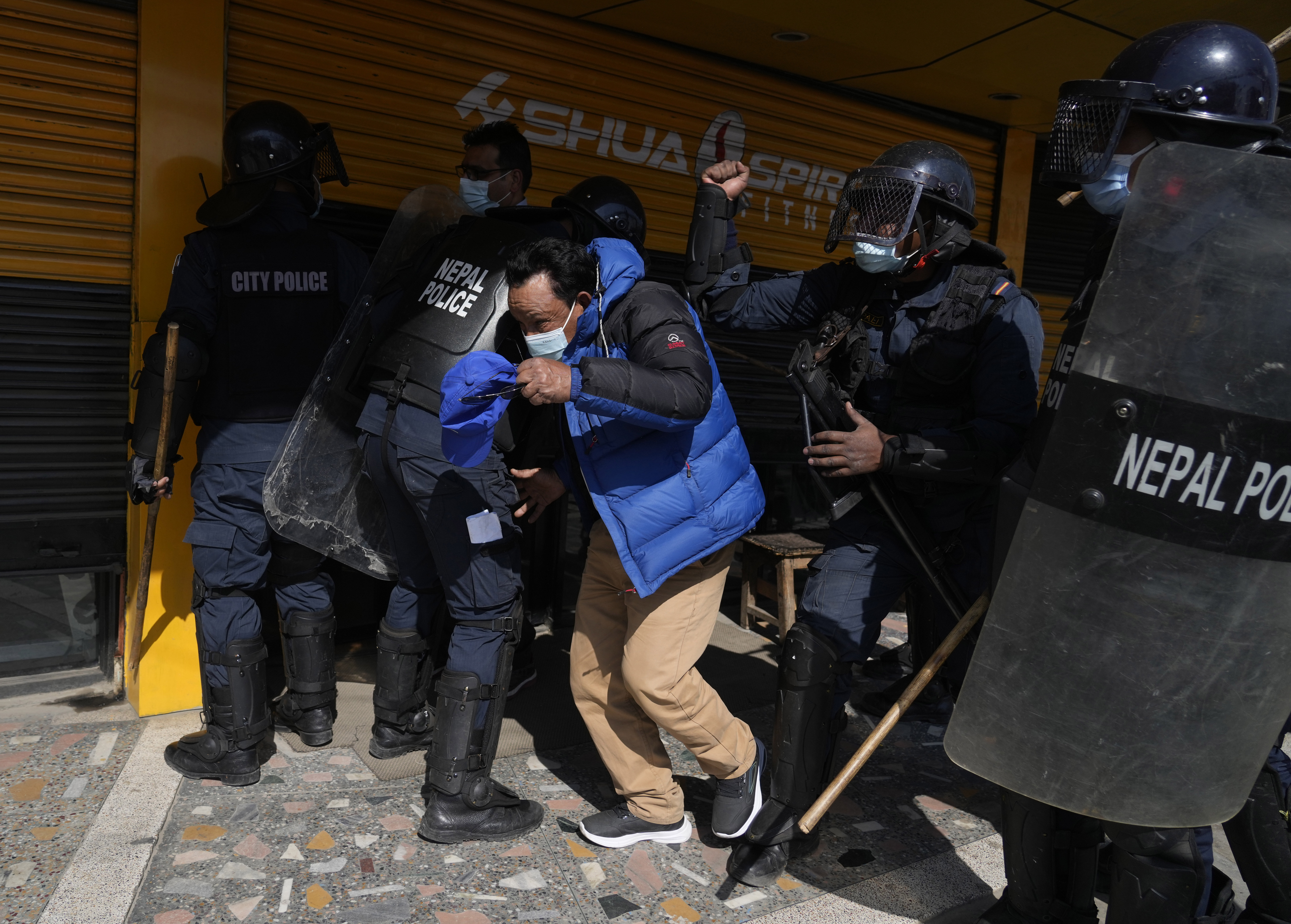 Nepalese police charge a protester