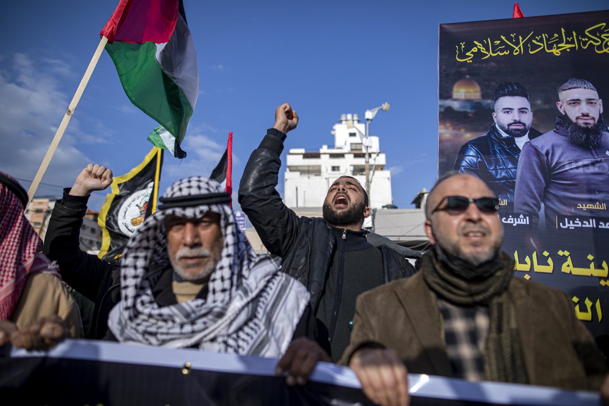 Palestinins chant slogans denouncing Israeli occupation.
