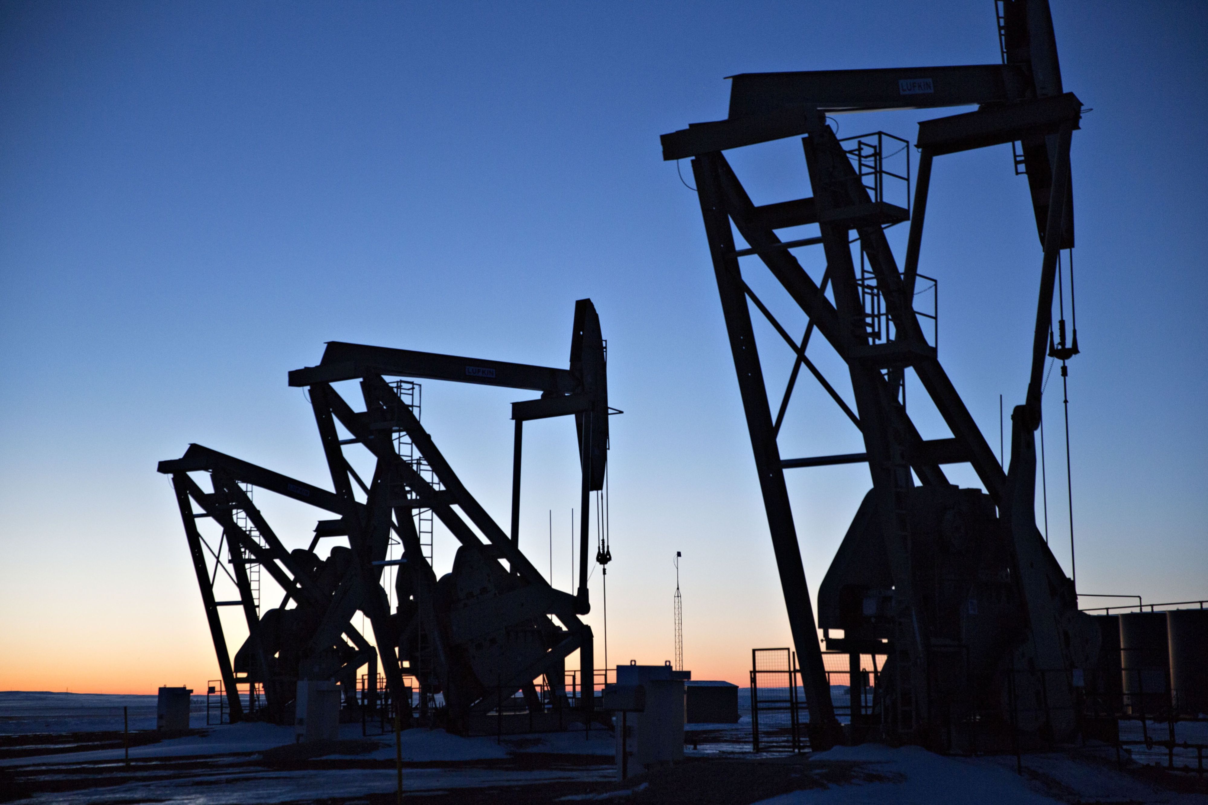The silhouettes of pumpjacks are seen above oil wells in the Bakken Formation in North Dakota, US
