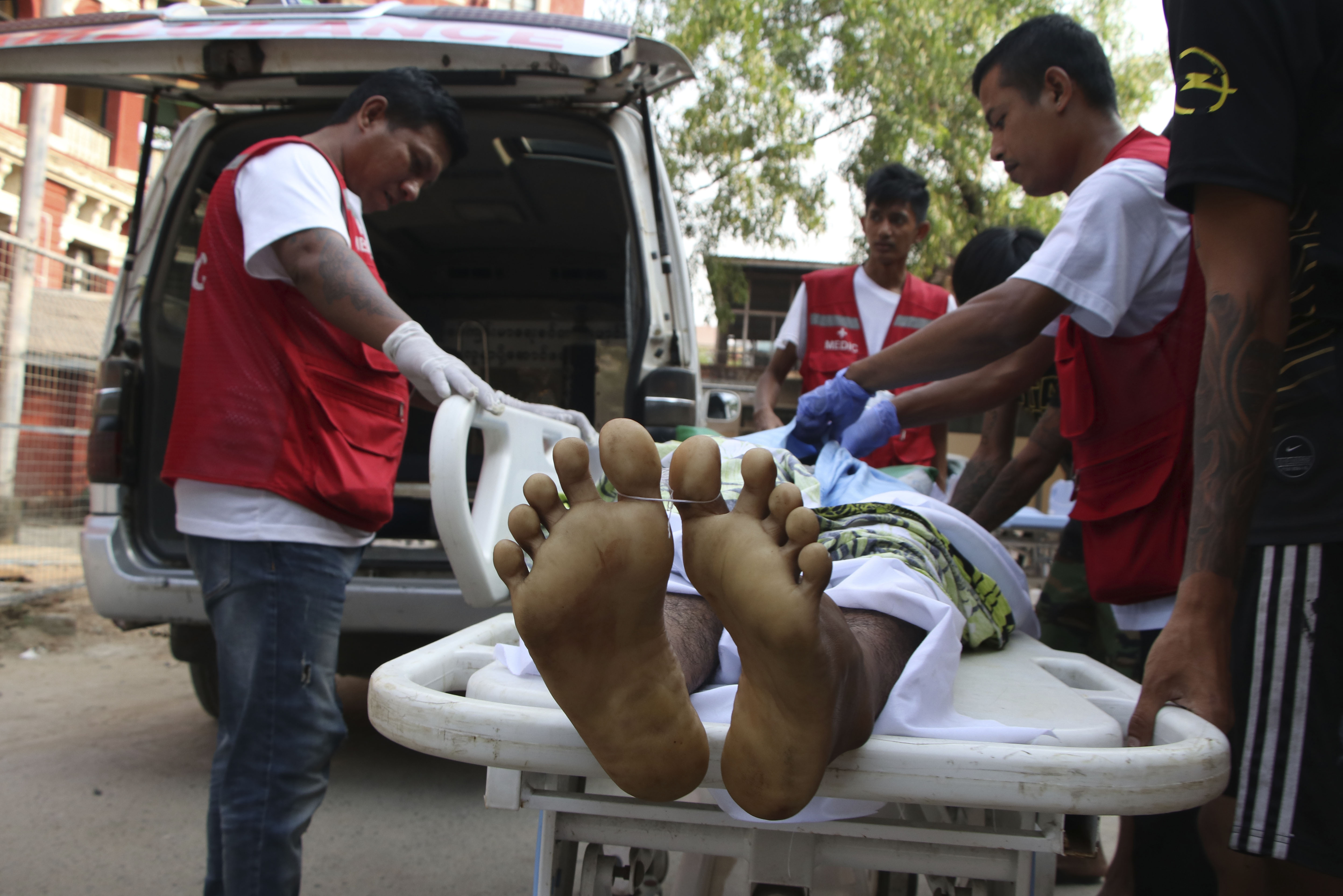 A man wheeled head first into an ambulance in Yangon following the military's brutal crackdown on protesters on Armed Forces Day in 2021