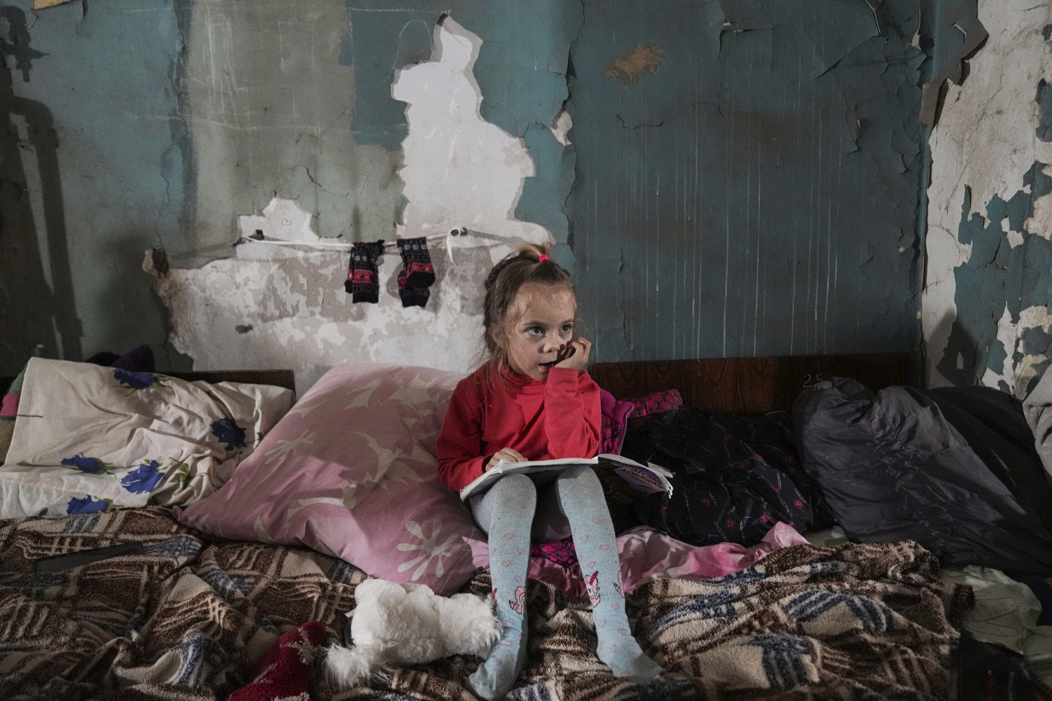 A girl sits in the improvised bomb shelte