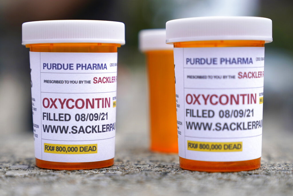 Fake pill bottles with messages about OxyContin maker Purdue Pharma are displayed during a protest outside the courthouse where the bankruptcy of the company is taking place in White Plains, New York.