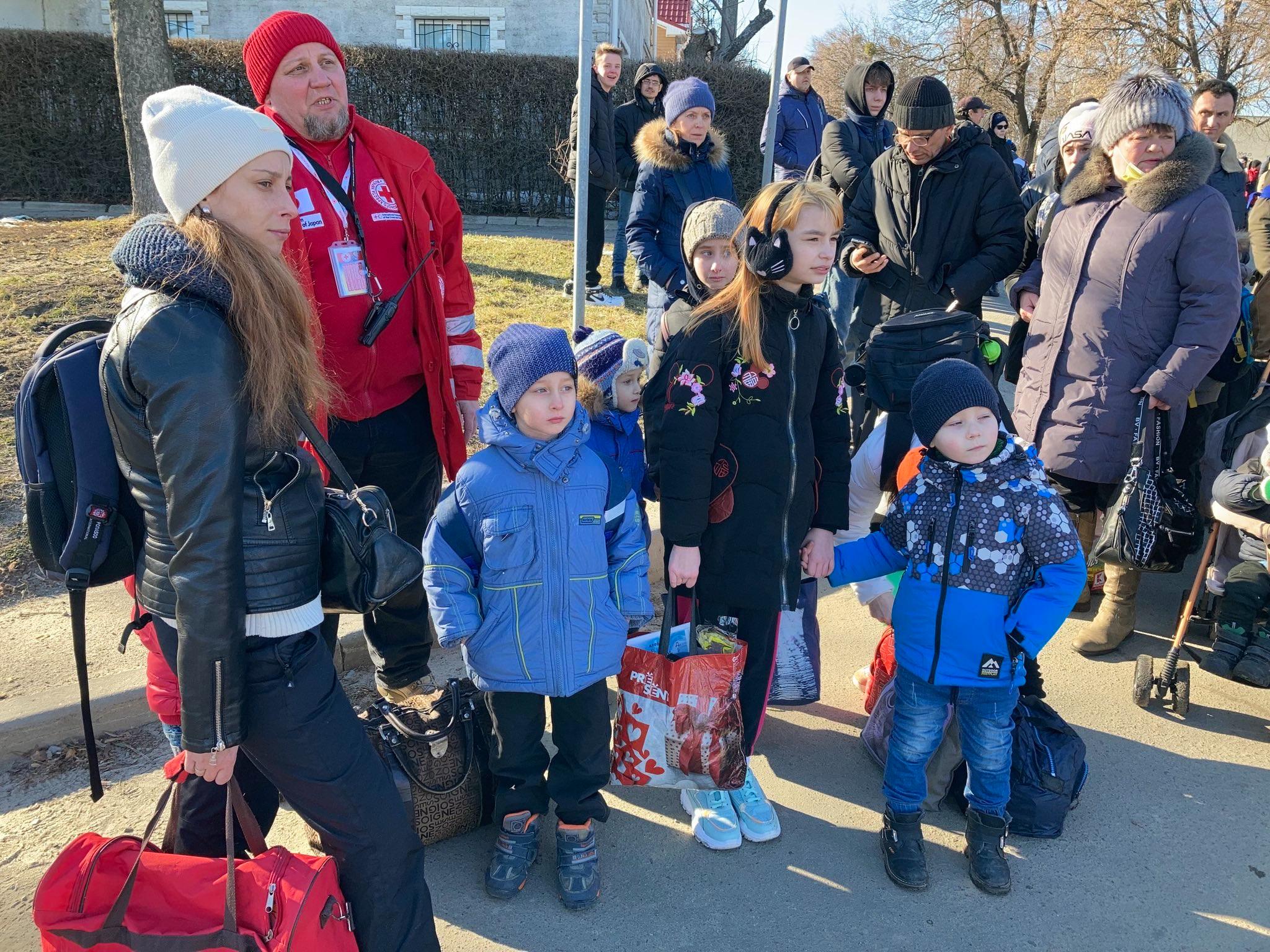Civilians stand as they wait to be evacuated from the besieged city of Sumy.