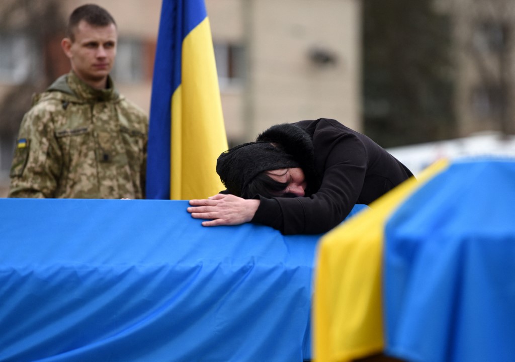 The mother of Ukrainian soldier Lubomyr Hudzeliak, who was killed during Russia's invasion of Ukraine, mourns over his flag-draped coffin during his funeral at the Lychakiv cemetery, in the western Ukrainian city of Lviv