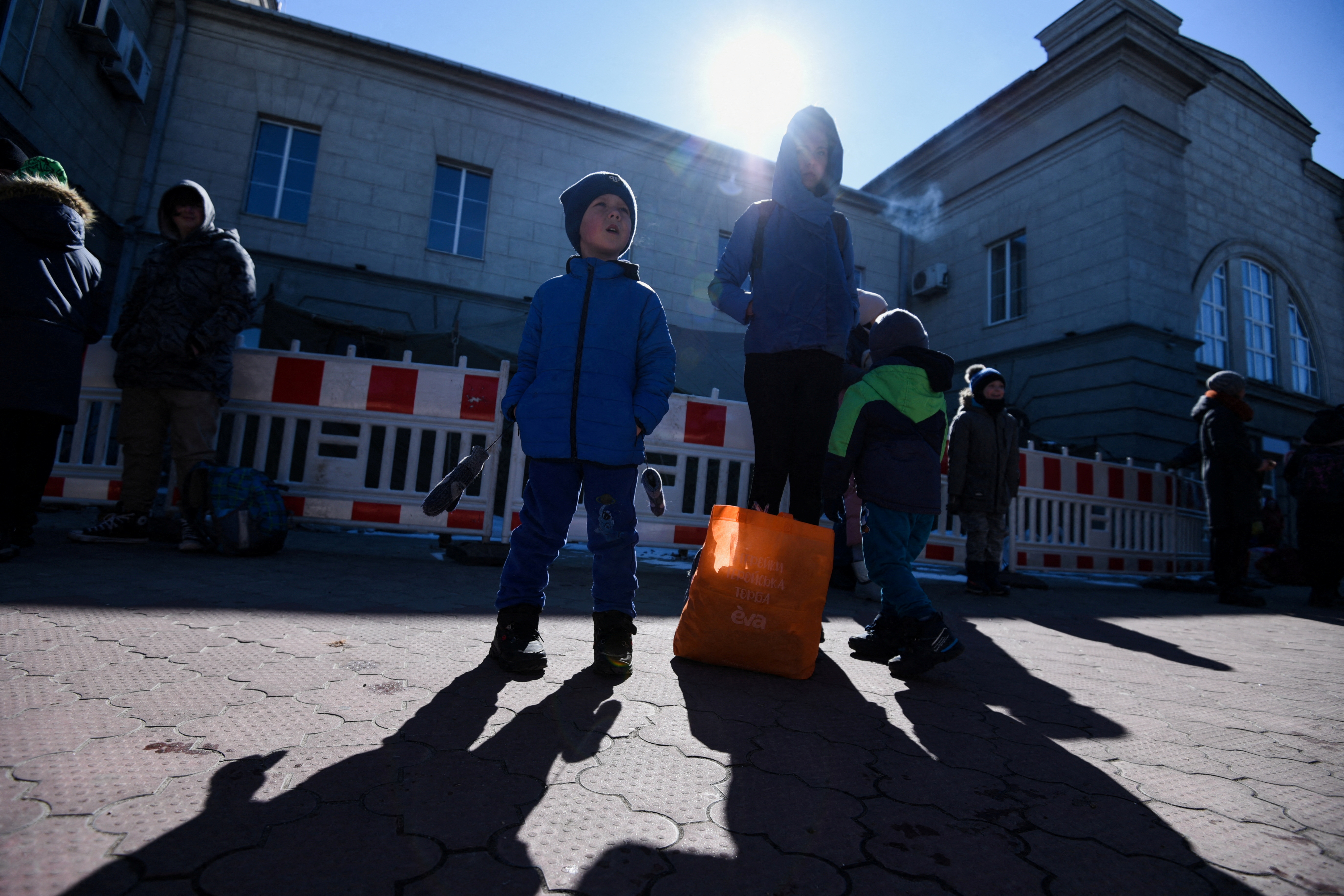 People with children wait at a train station in Dnipro, Ukraine.