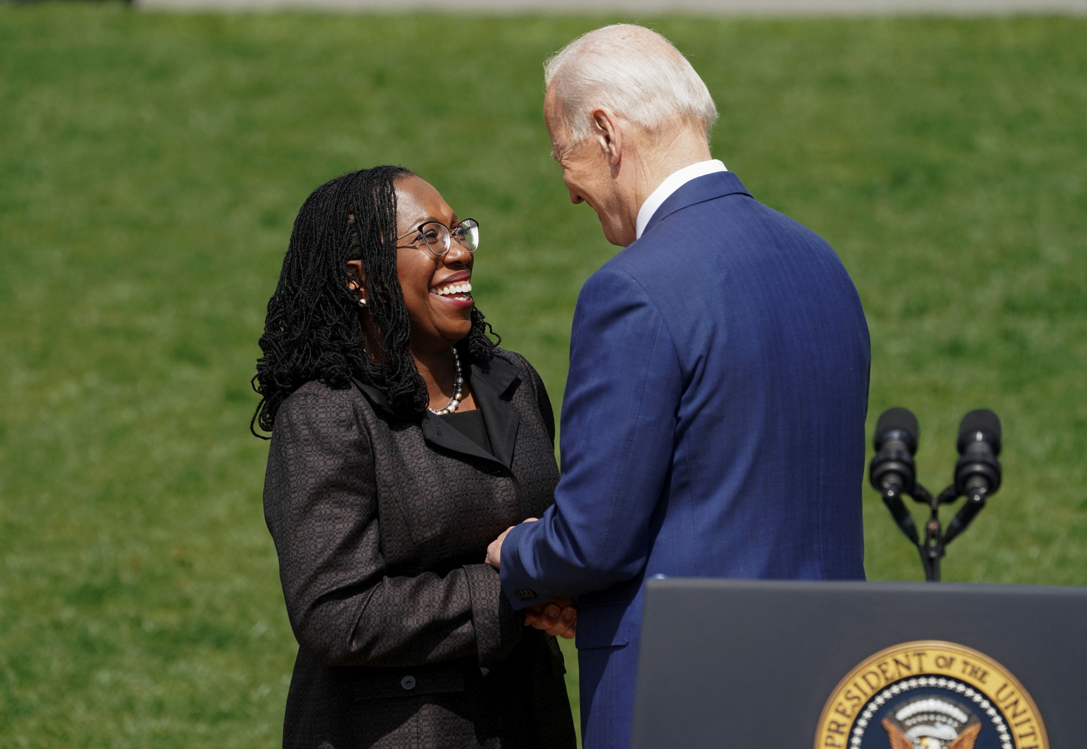 Judge Ketanji Brown Jackson holds hands with US President Joe Biden