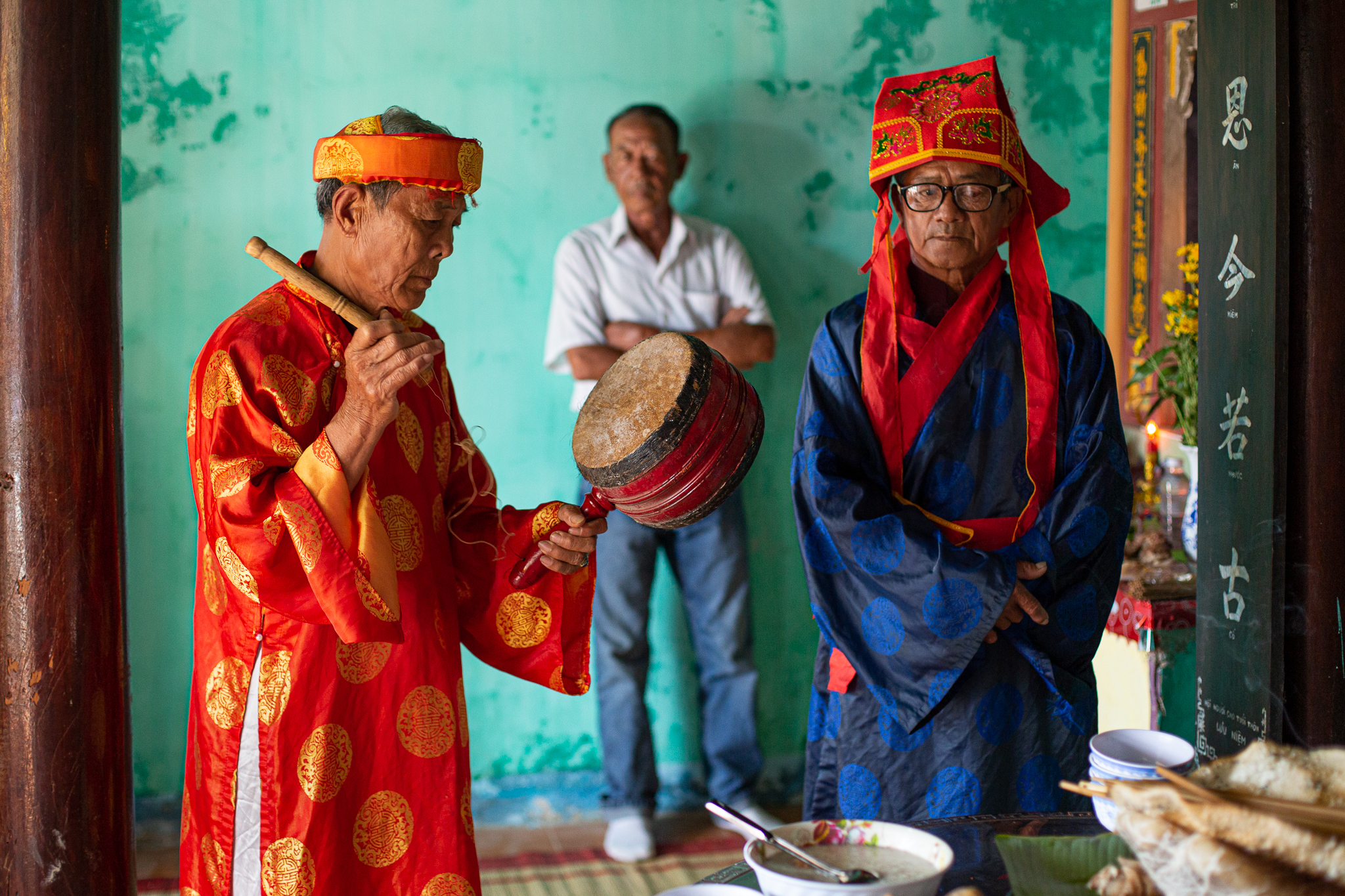 A photo of leaders of the whale worshipping community performing rituals in a temple.
