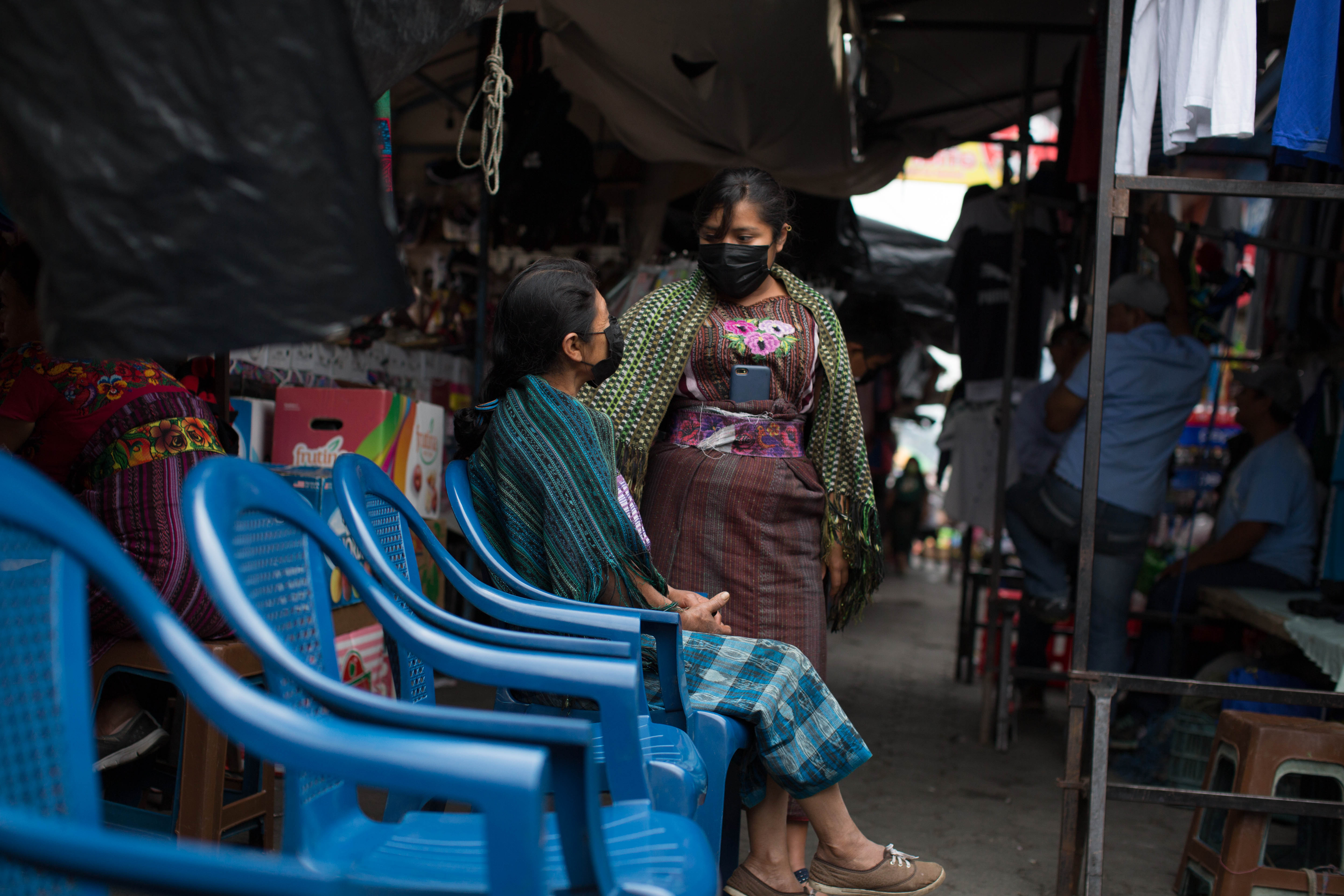 A woman and her daughter sit outside the Santiago Atitlan health clinic in the center of the town on April 8
