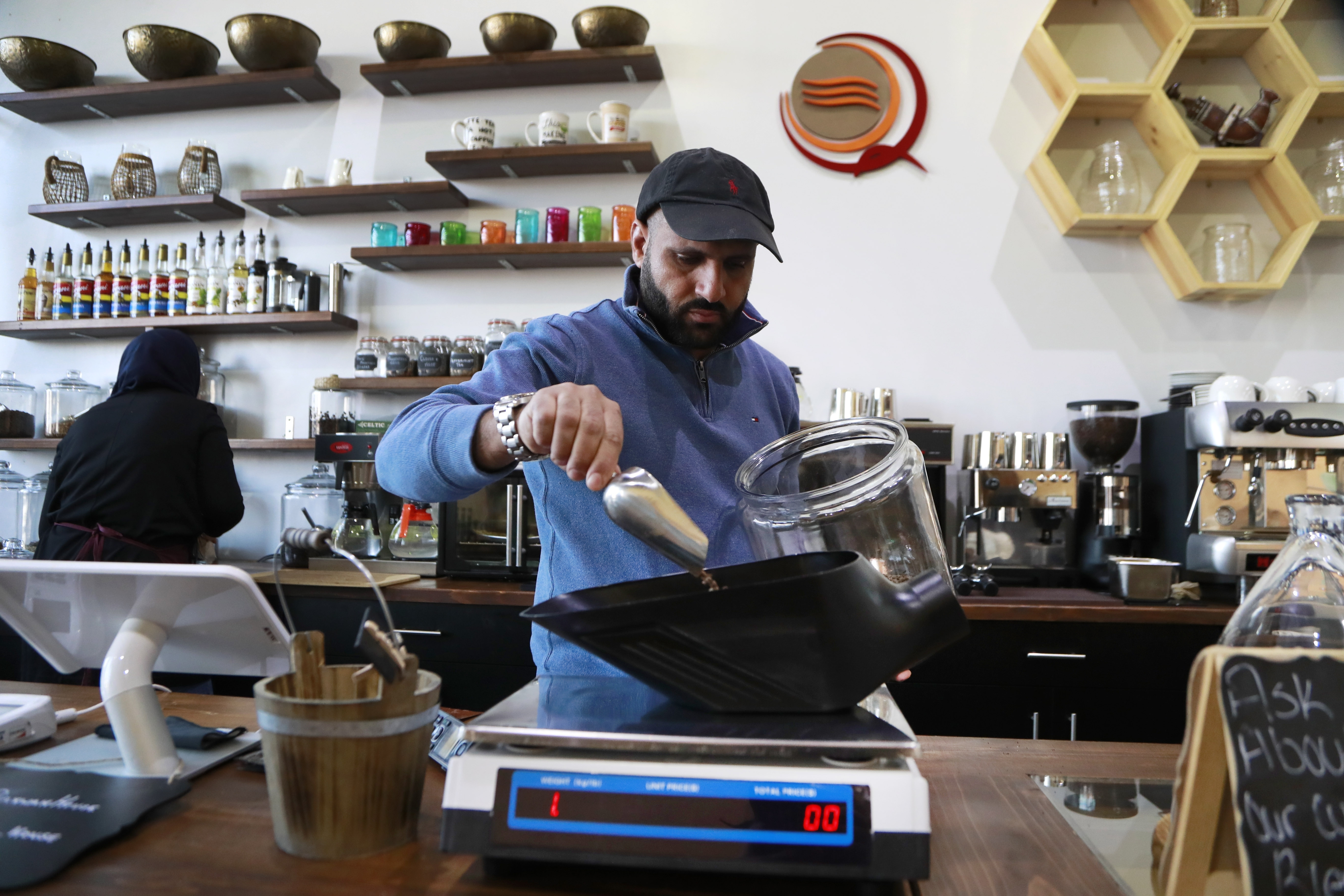 Ibrahim Alhasbani, owner of Qahwah House in Dearborn, Michigan, measures coffee