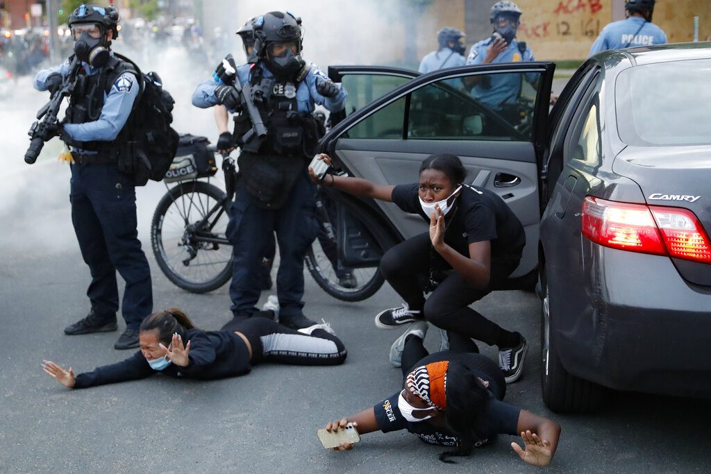 Black motorists are ordered to the ground from their vehicle by police on during a protest in Minneapolis over the killing of George Floyd.