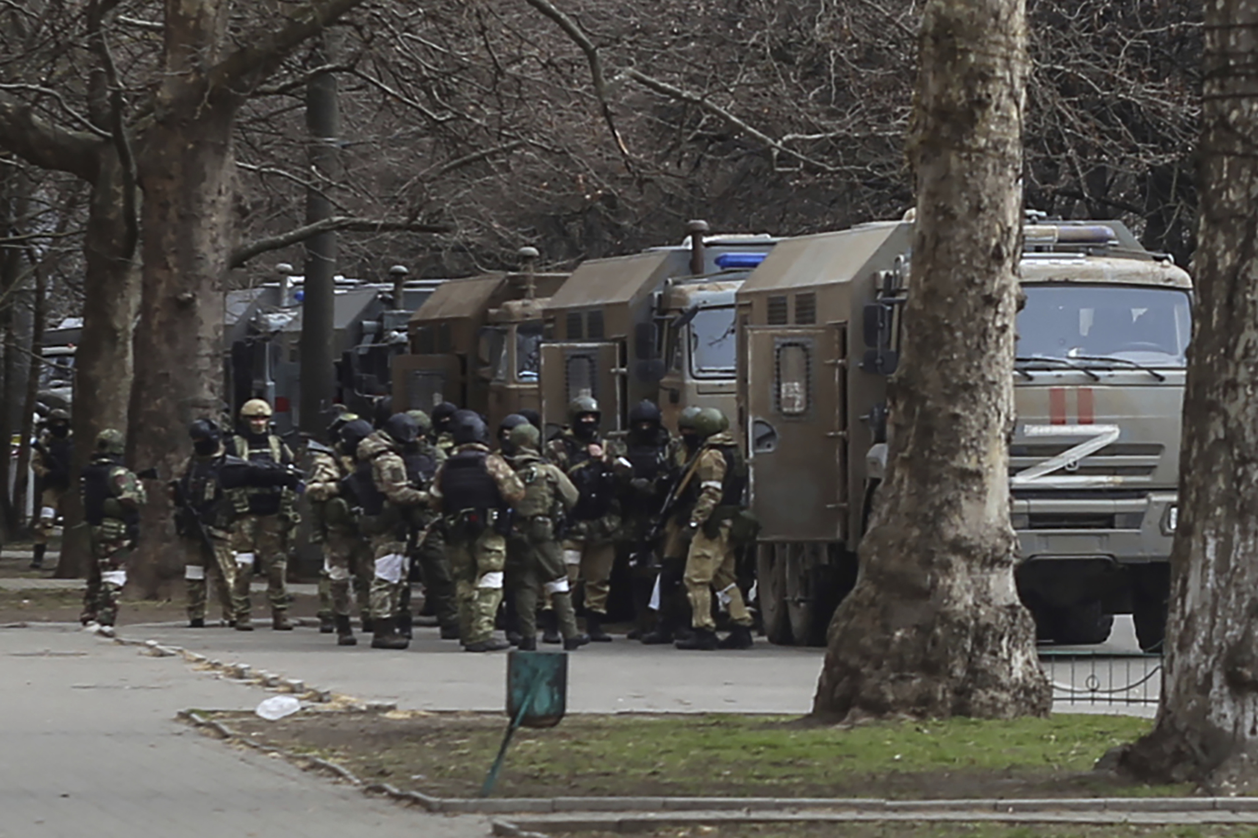 Russian army soldiers stand next to their trucks during a rally against Russian occupation