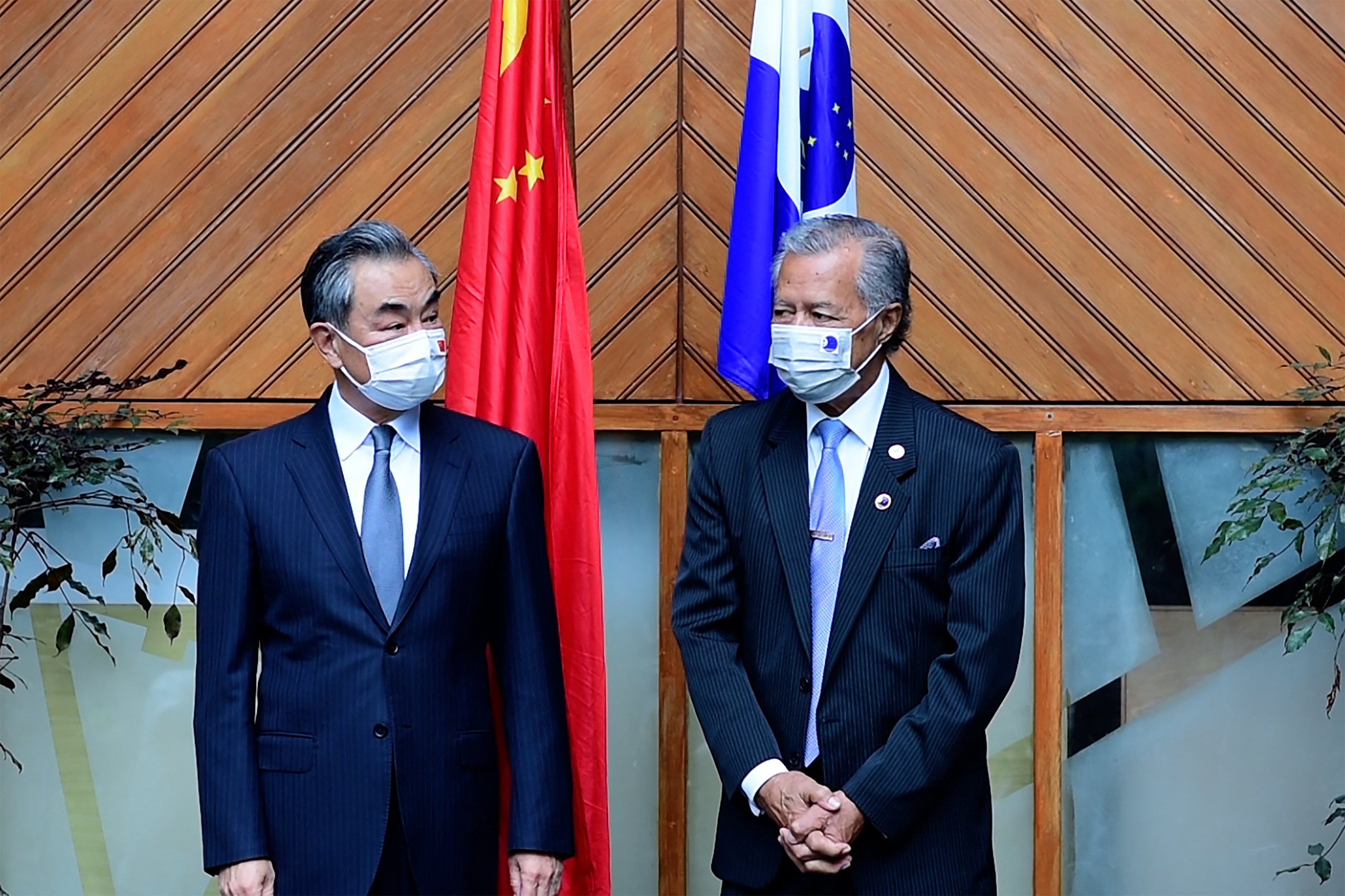 Secretary-General of the Pacific Islands Forum Henry Puna (R) and Chinese Foreign Minister Wang Yi (L) pose for photographs during their meeting in Fiji's capital city of Suva.