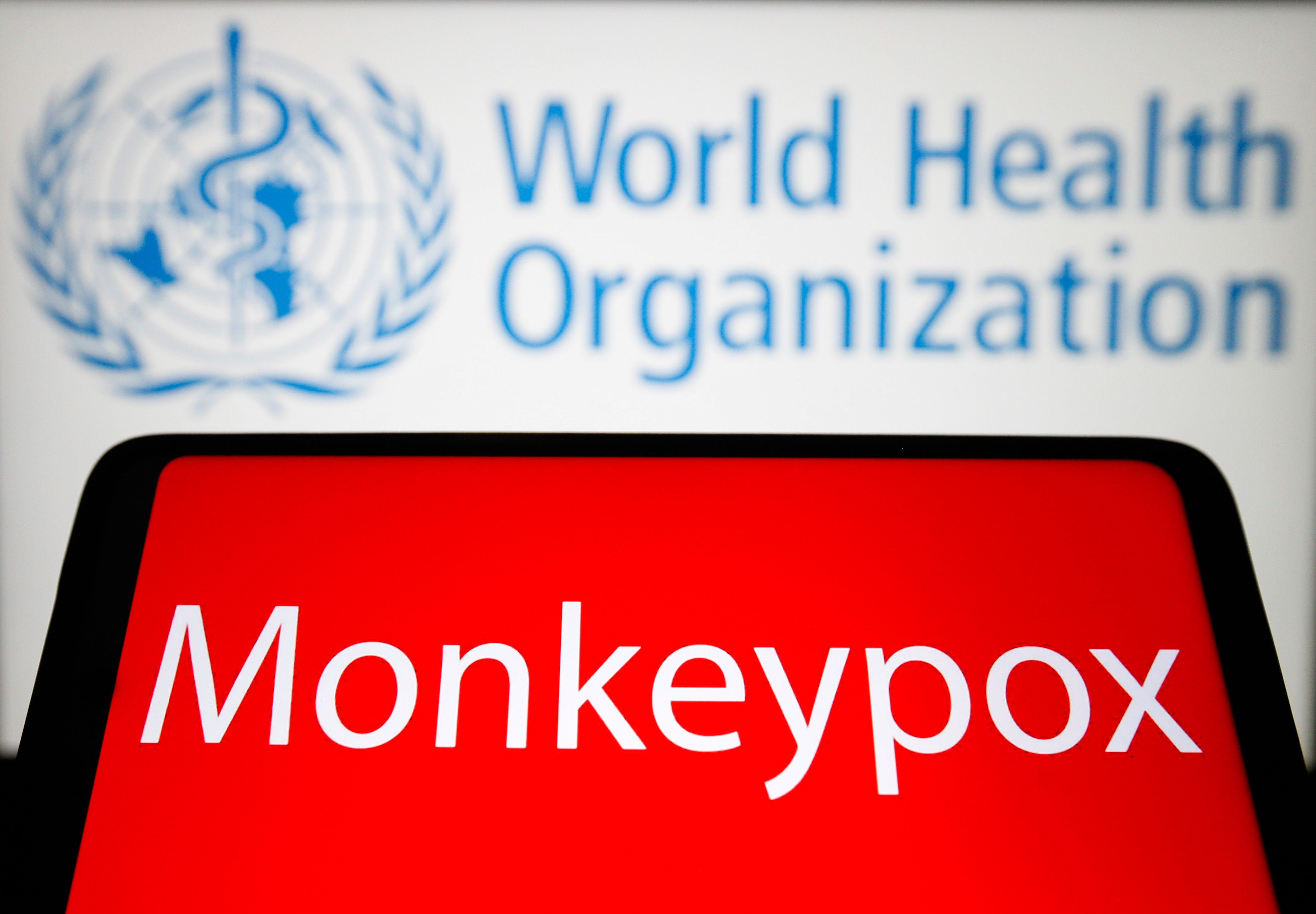 The word Monkeypox is seen on the screen of a smartphone with the World Health Organization (WHO) logo in the background.