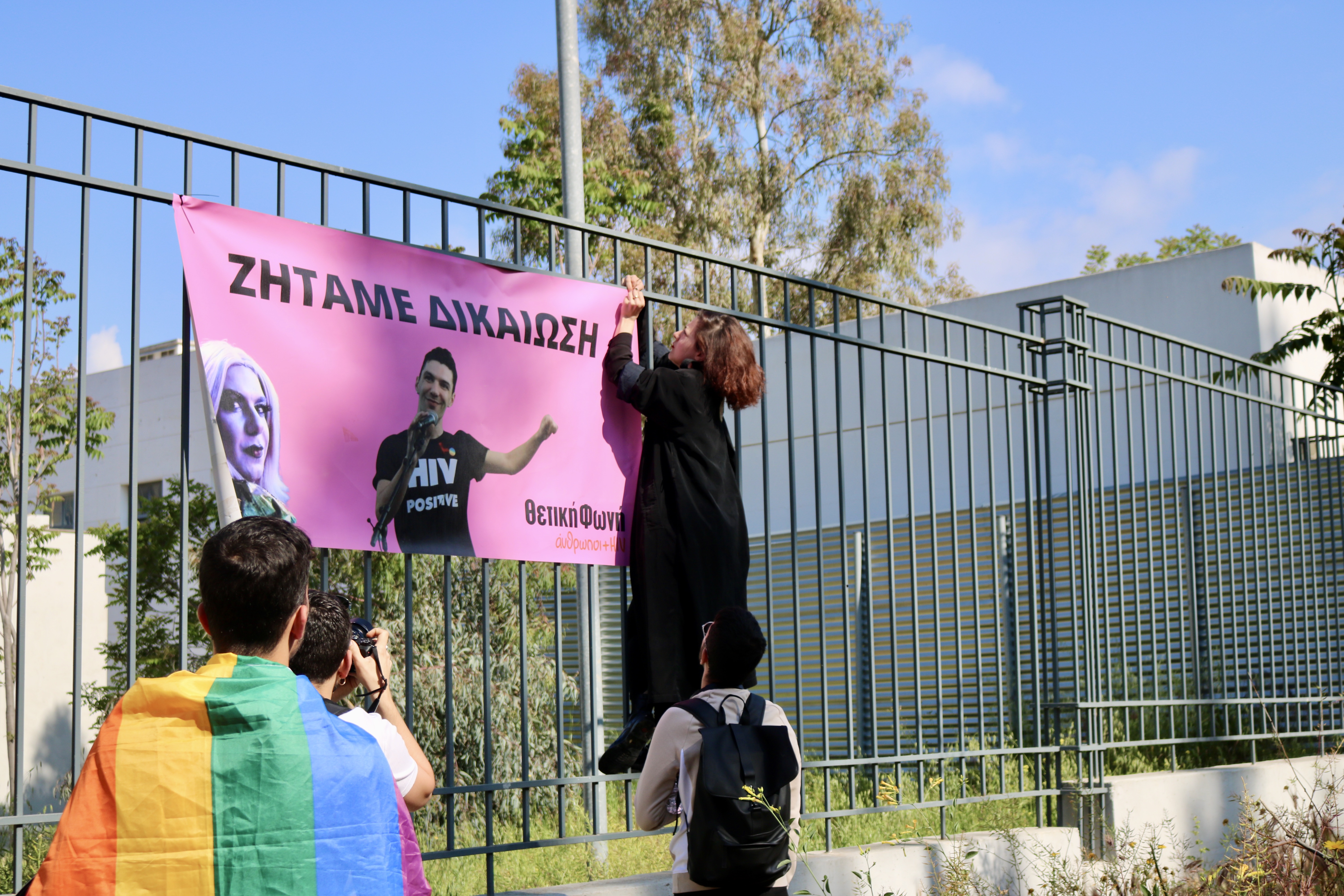 Activists hang up a poster of Zak Kostopoulos