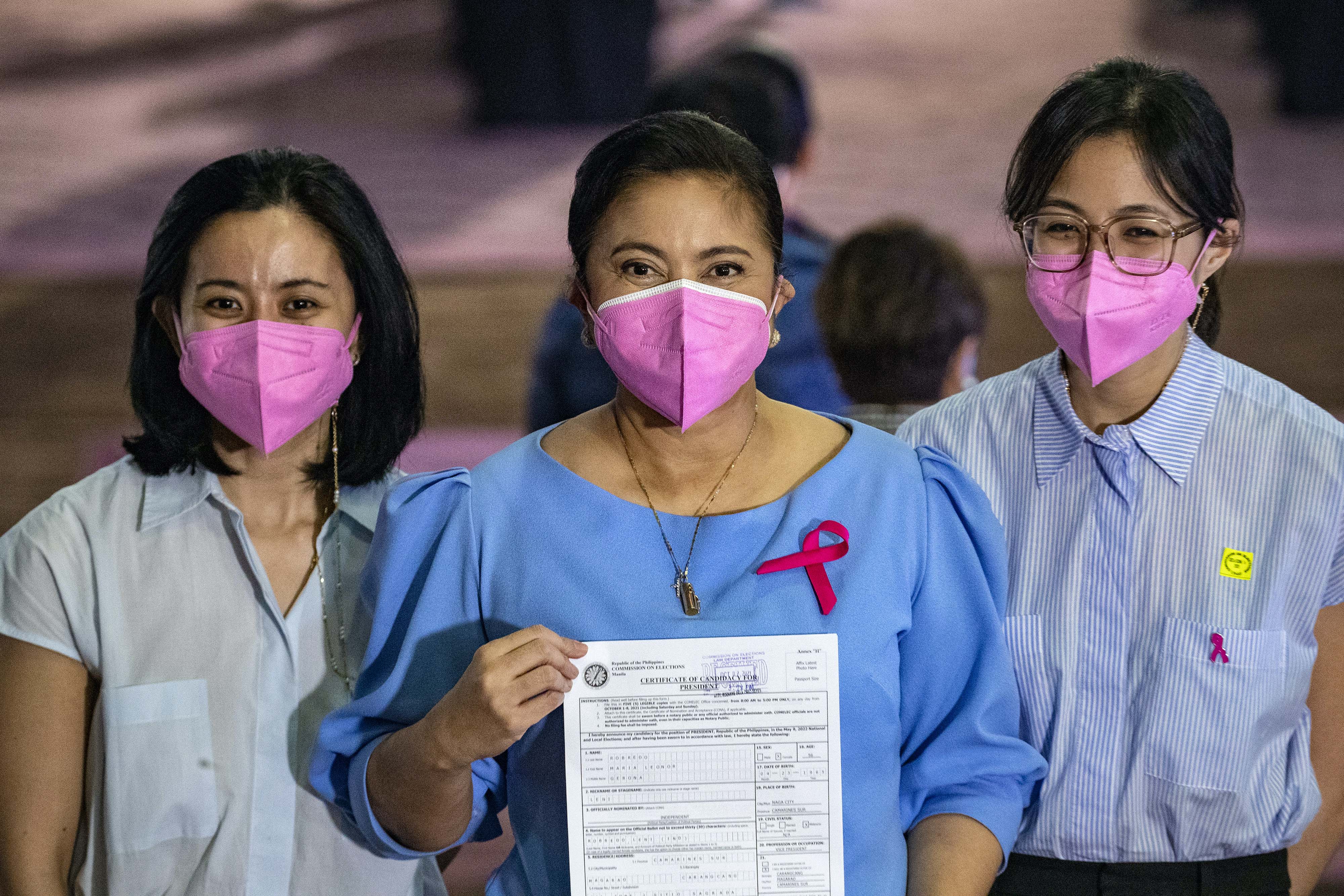Robredo stands between her two daughters holding her certificate of candidacy for the presidential election 