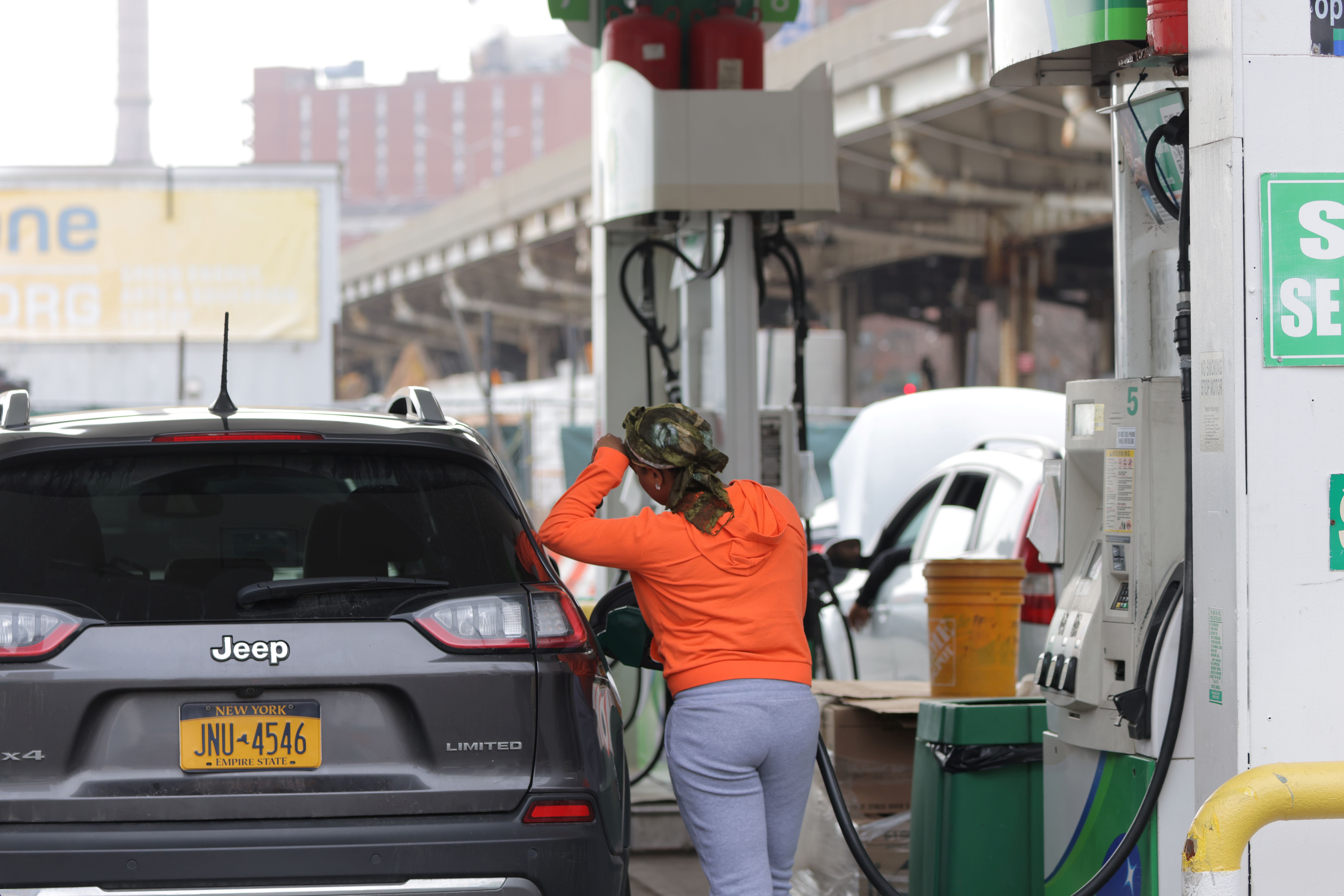 A person uses a petrol pump at a gas station as fuel prices surged in Manhattan, New York City, U.S.