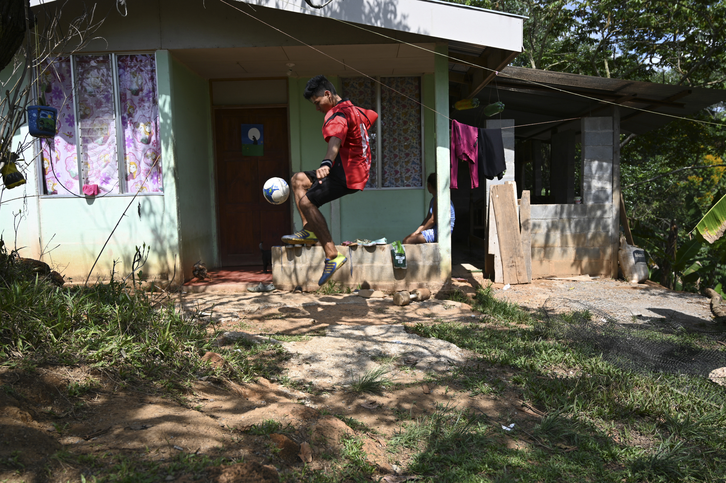 A photo of Junior Jara, 22, a student from Salitre, playing football outside his new home.