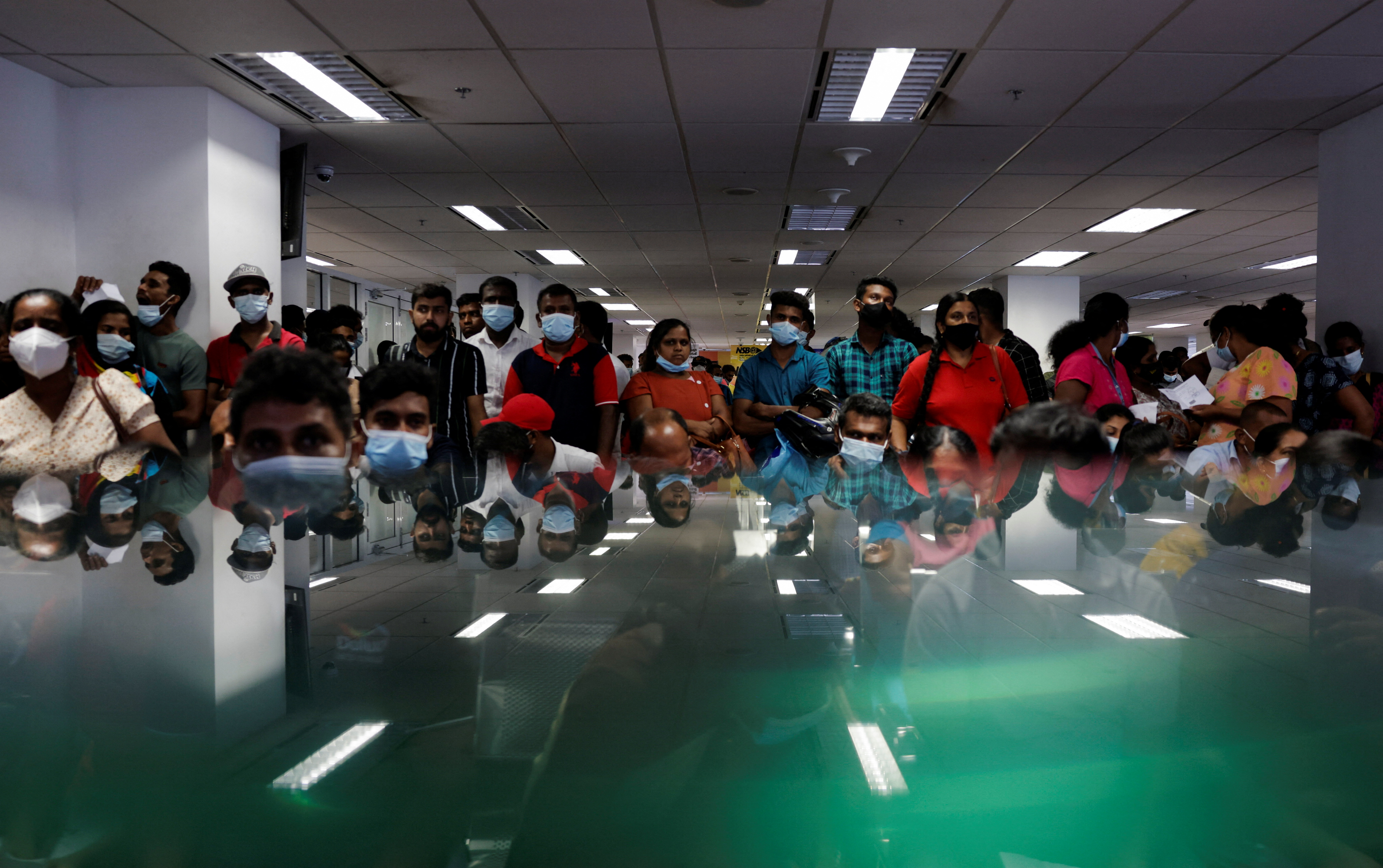 People wait to collect their passports