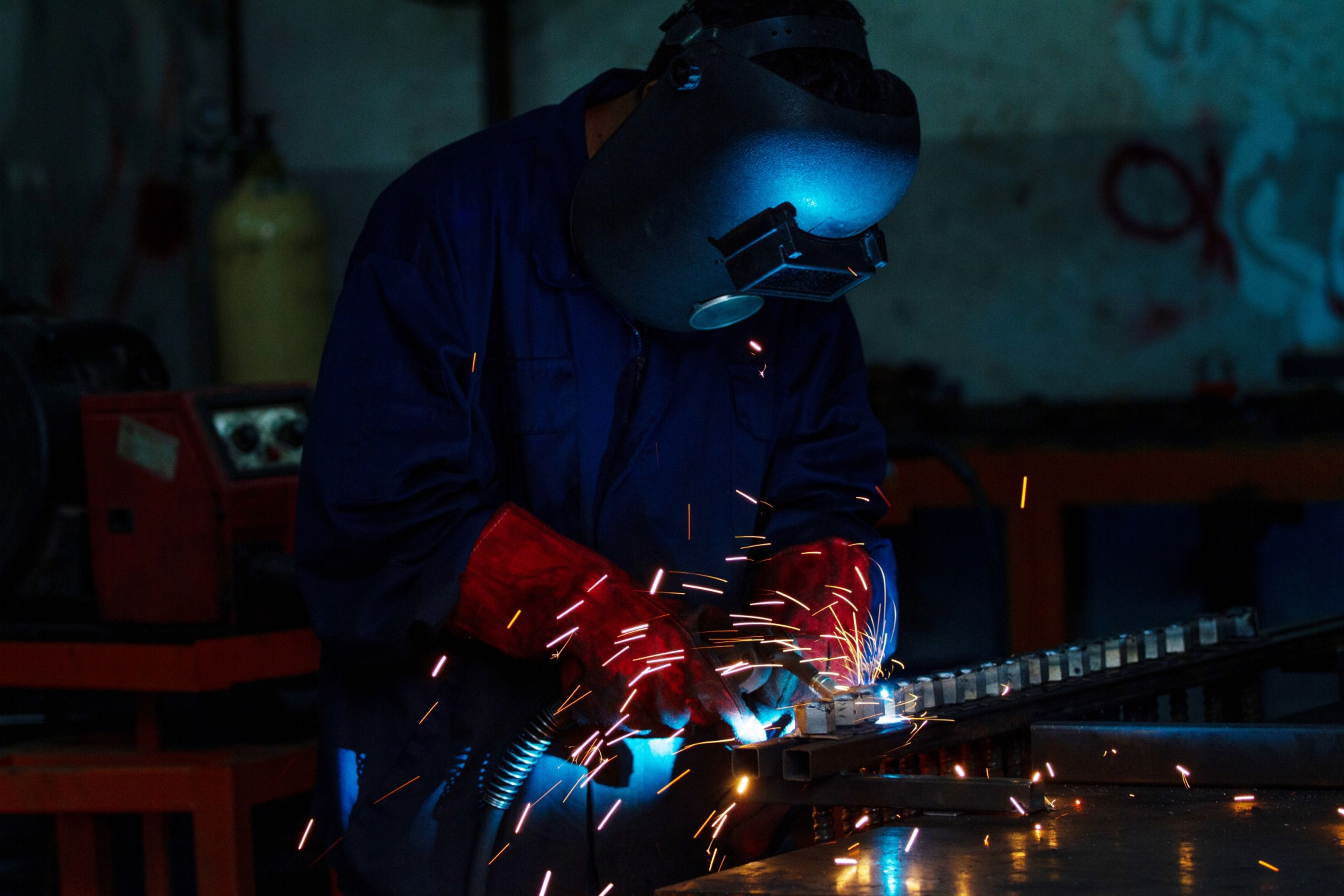 A worker uses a welding torch on an aluminum formwork part in Selangor, Malaysia