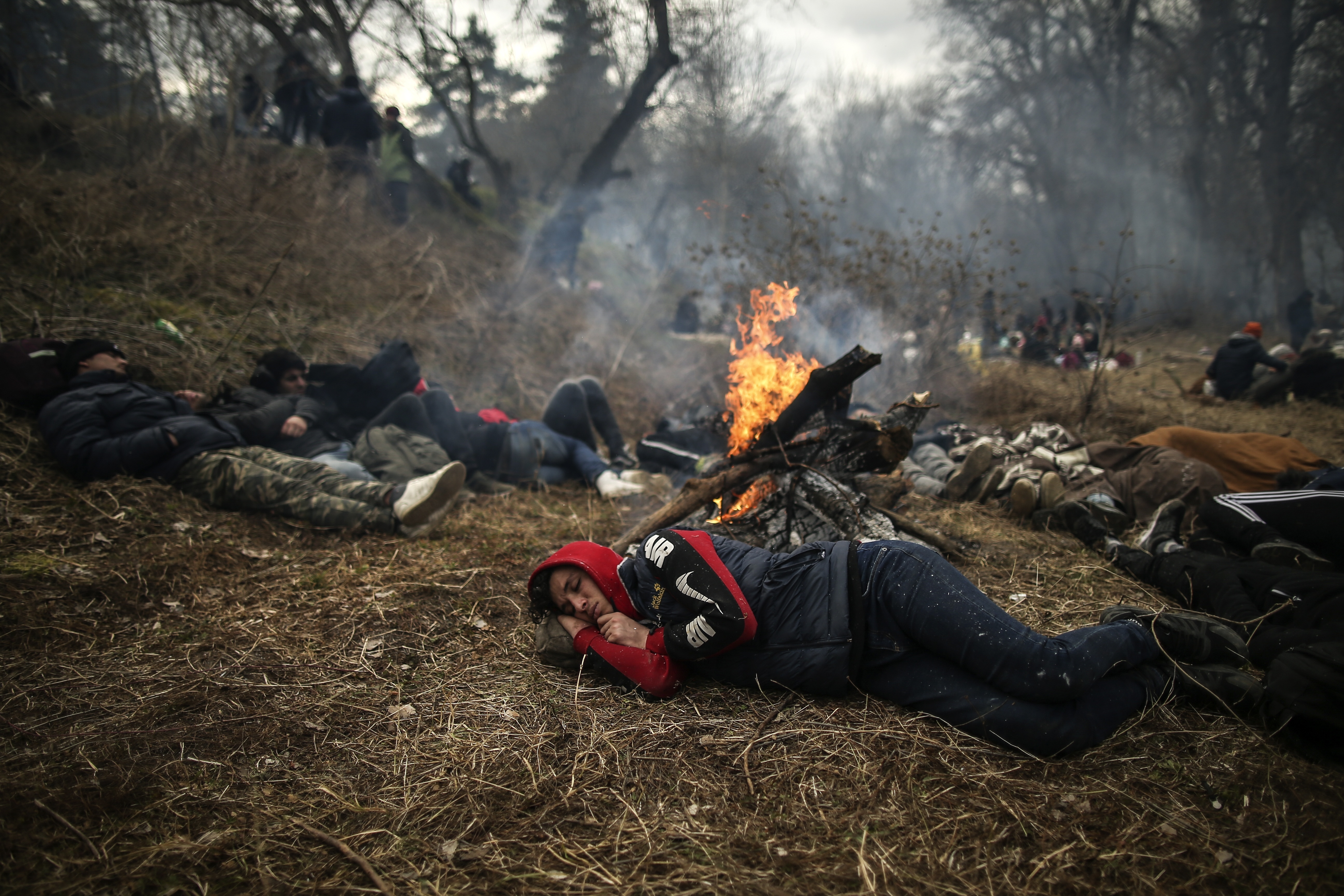 Migrants rest near Pazarkule border gate, Edirne, Turkey, at the Turkish-Greek border 