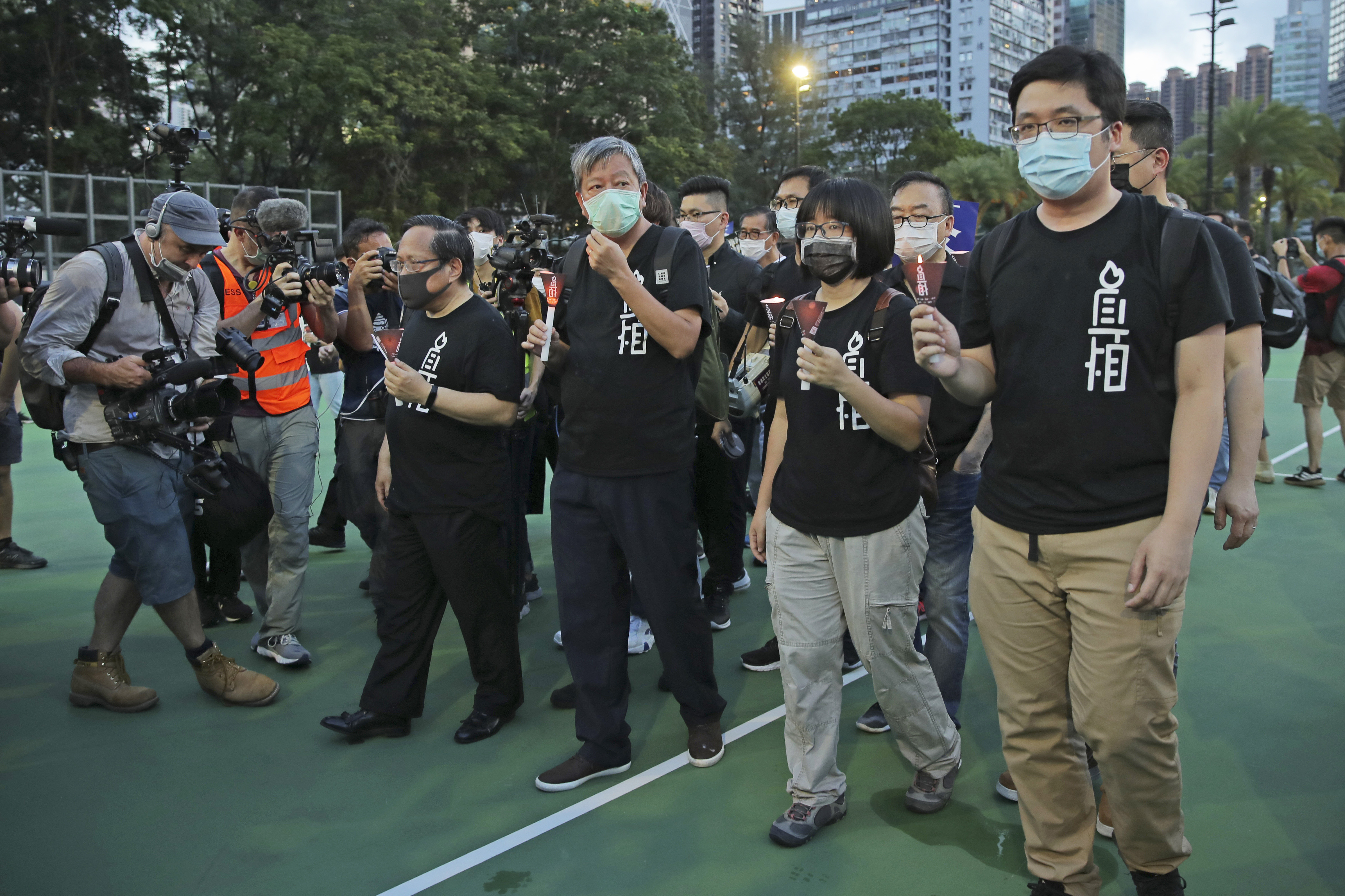 Lee Cheuk-yan, third right, and Chow Hang Tung, second right, walk through Victoria Park on June 4 last year 