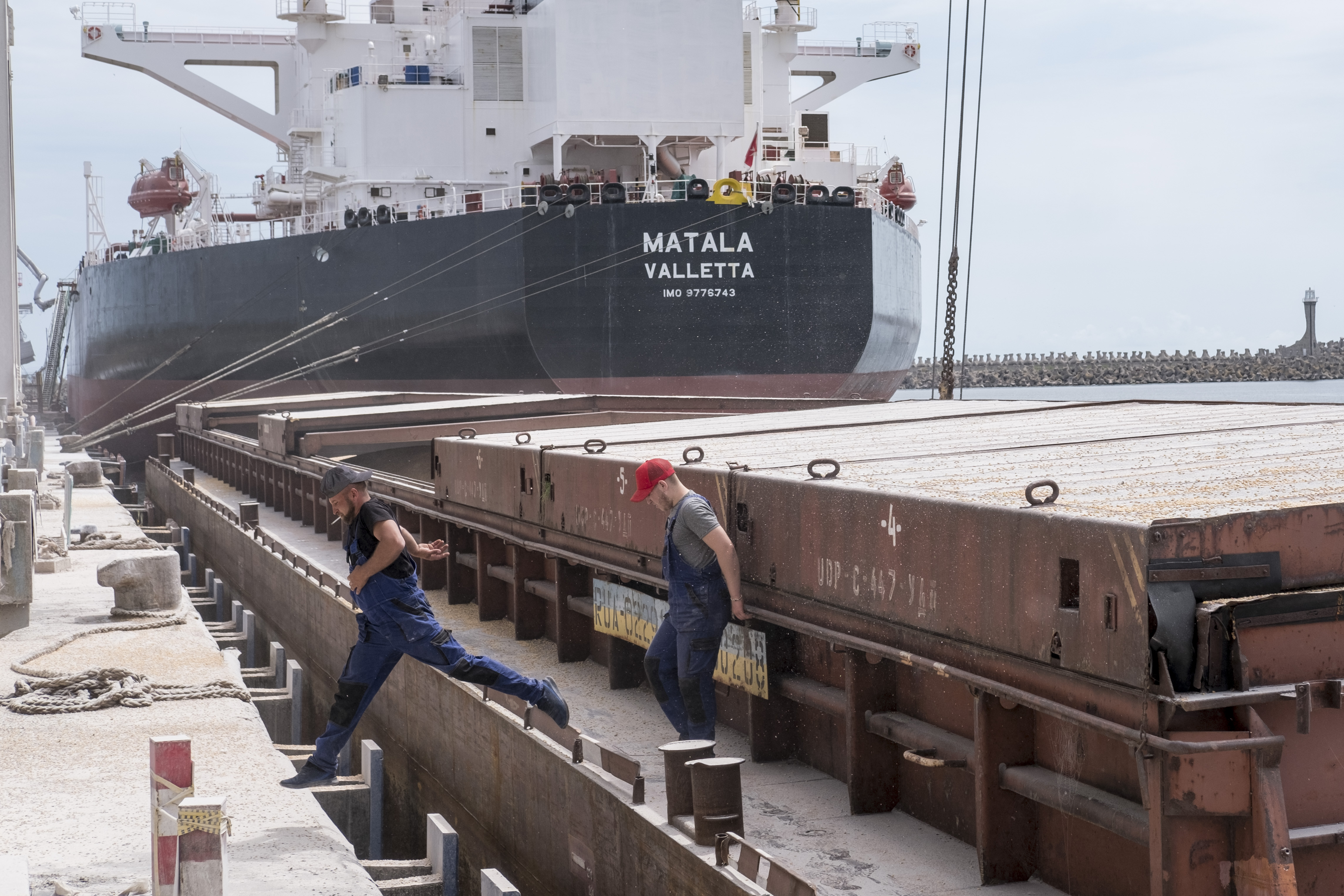 Workers move from a Ukrainian cereal barge that was being unloaded. Constanta port's connection to the Danube river, the low cost of transportation and the large quantities that can be shipped on the Danube by barge offer an efficient alternative to the congested European rail and road transport.