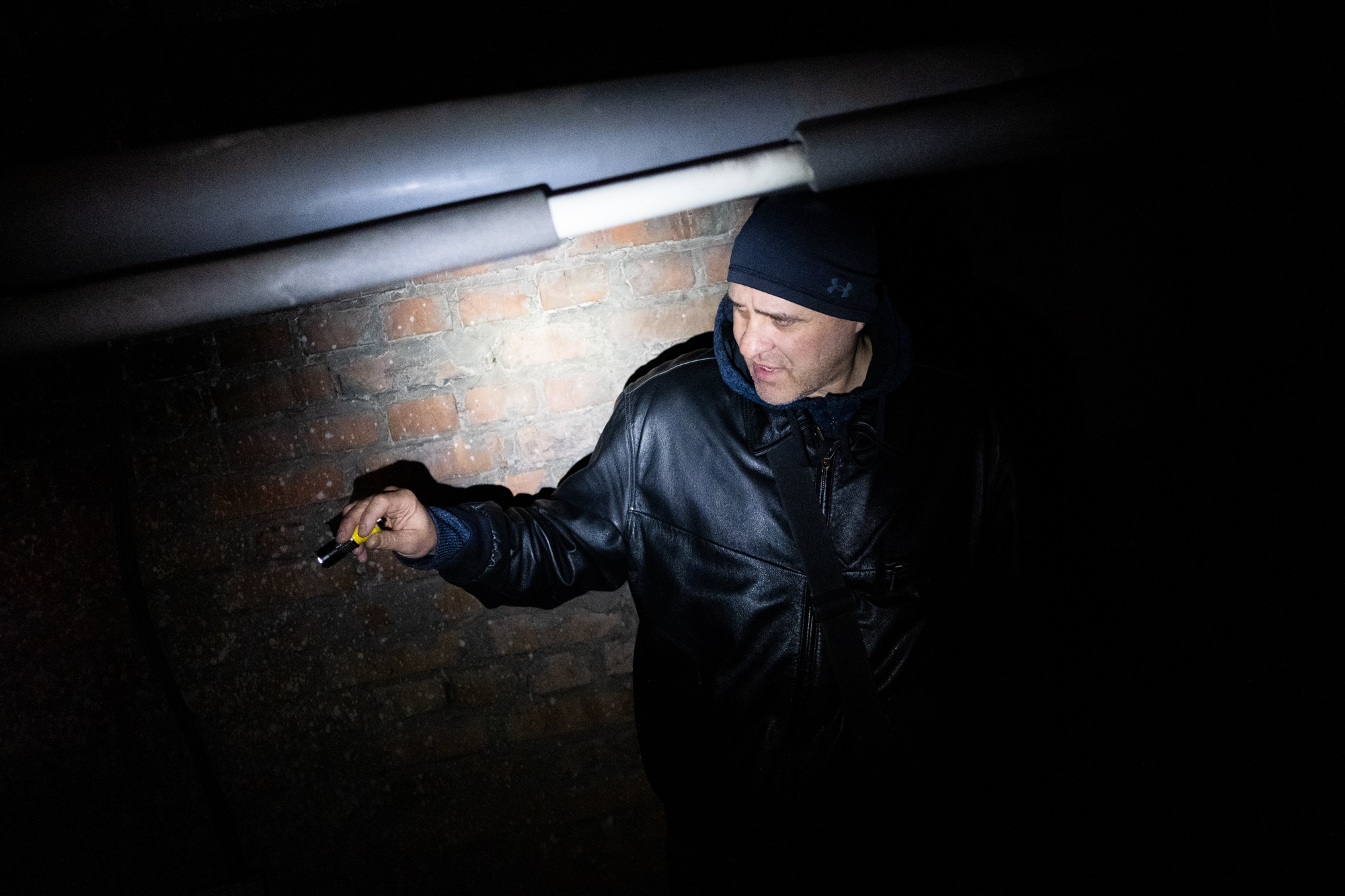 A photo of Andrii Kurpich standing in a dark basement.