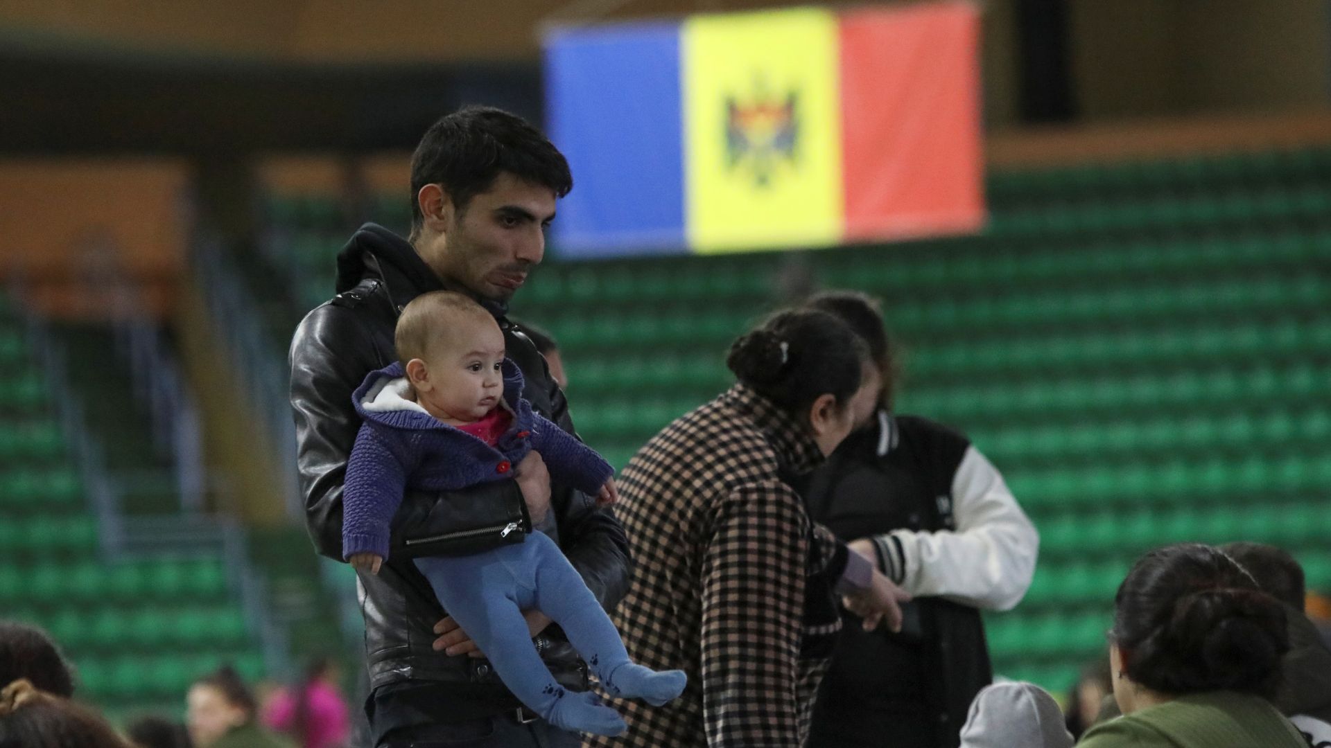 People fleeing Russia's invasion of Ukraine rest near the Moldova flag