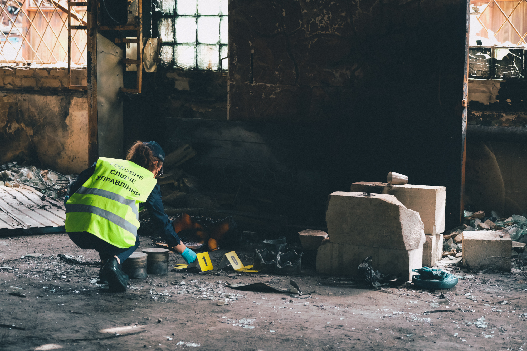 A photo of Natalya Kozhevnykova sifting through the wreckage at the former makeshift Russian army base.