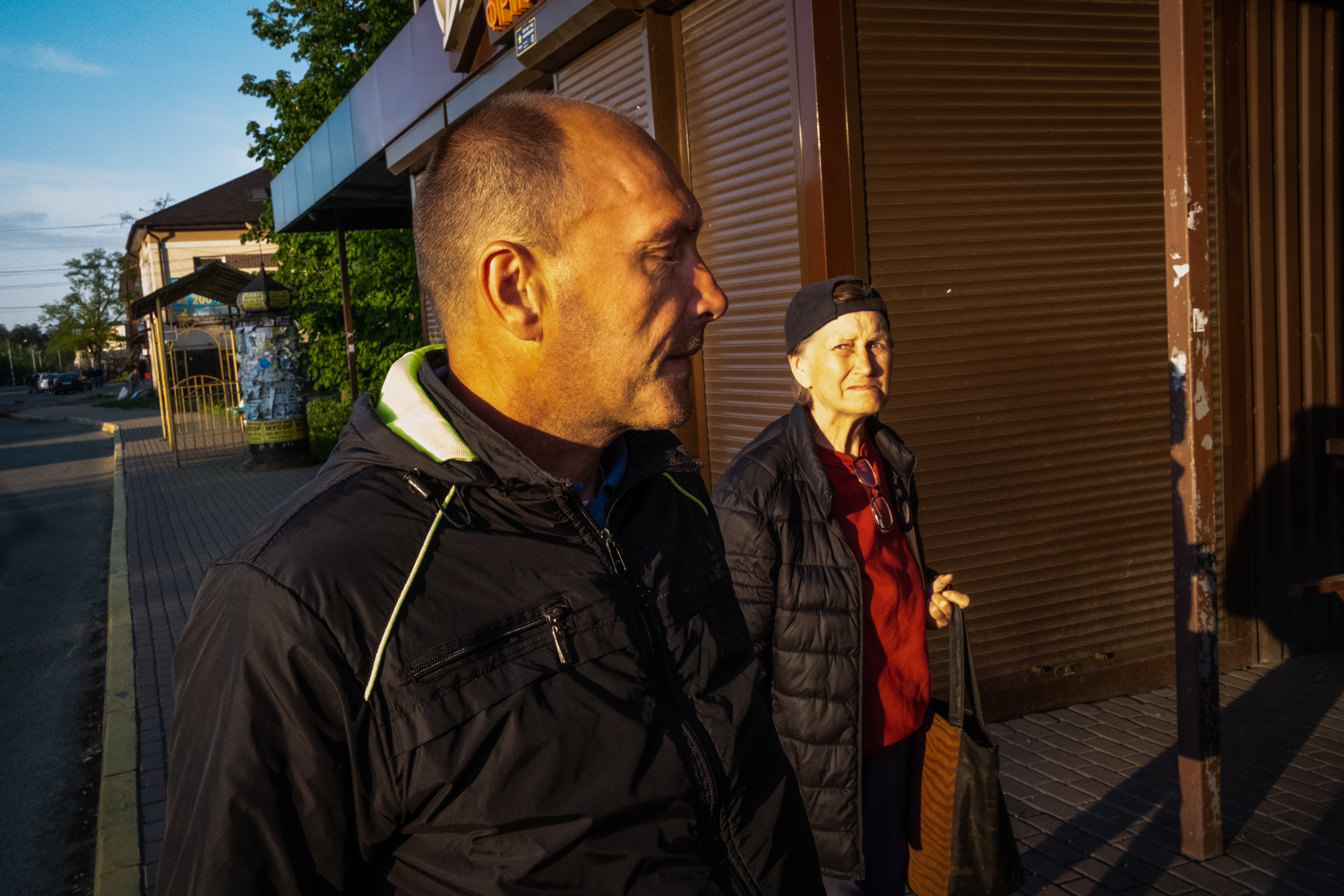 A photo of Oleh Karpov walking on a sidewalk with someone next to him.
