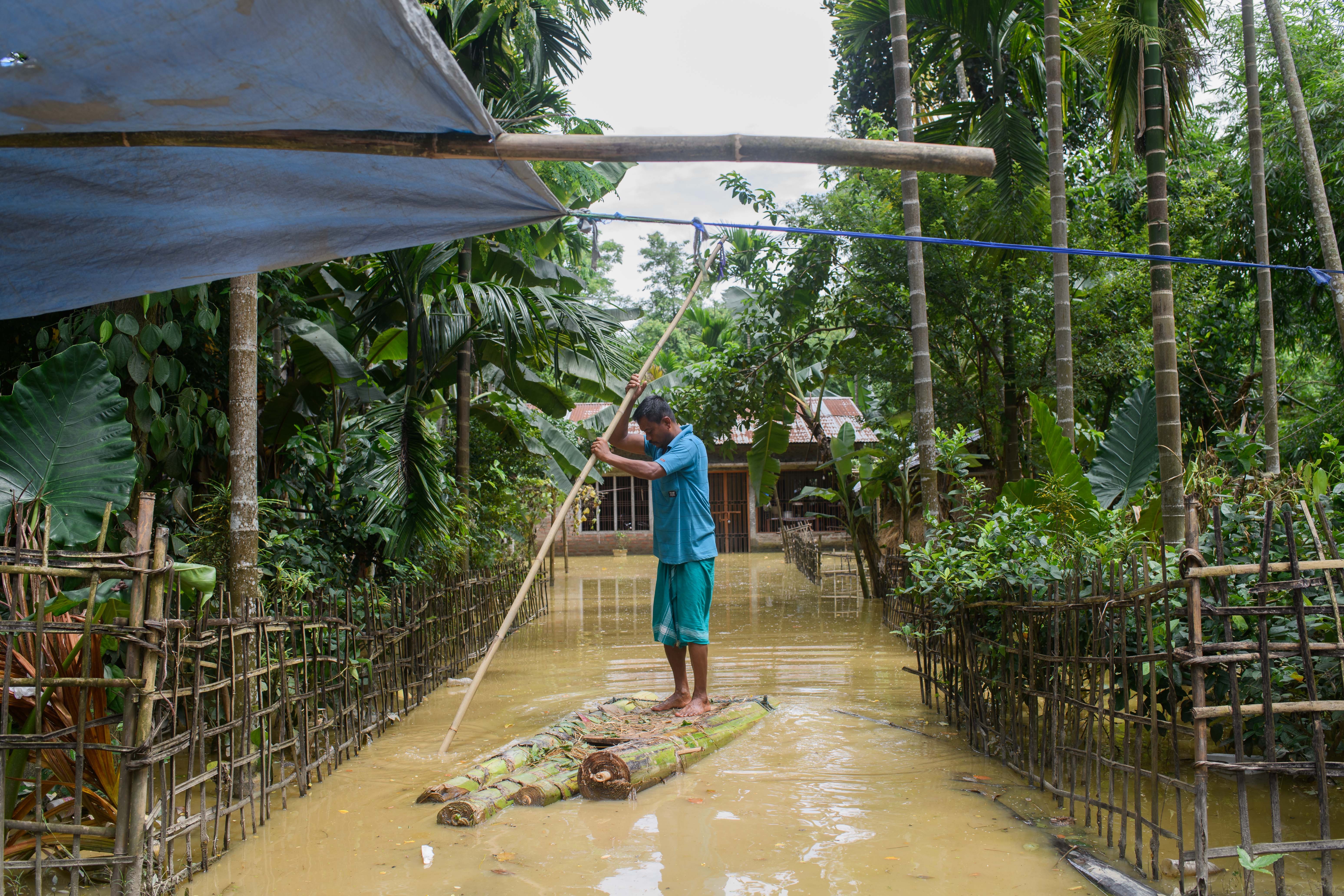 Srimanta Deka in front of his home on a raft made out of Banana tree trunks in Ruapahitoli, Raha