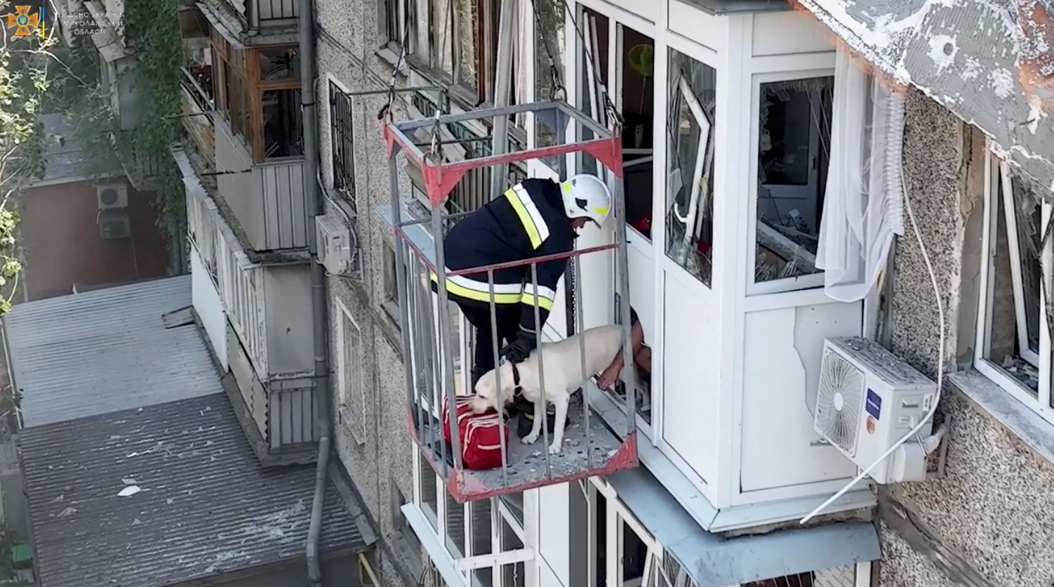 Rescuers evacuate a dog from a damaged residential building following a missile attack in Mykolaiv, Ukraine.