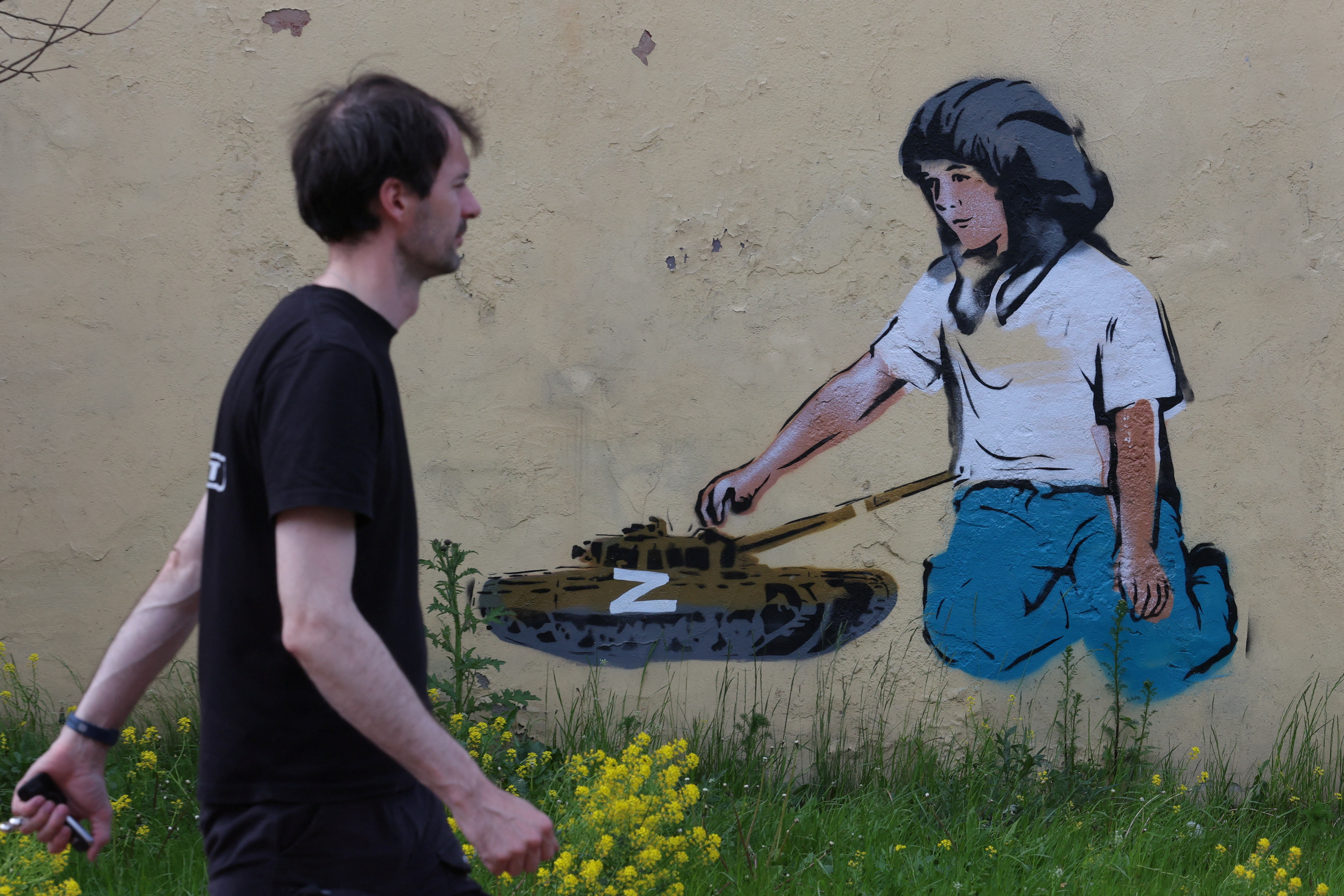 A man walks past a graffiti depicting a tank with the Z symbol in central Saint Petersburg, Russia June 2, 2022 