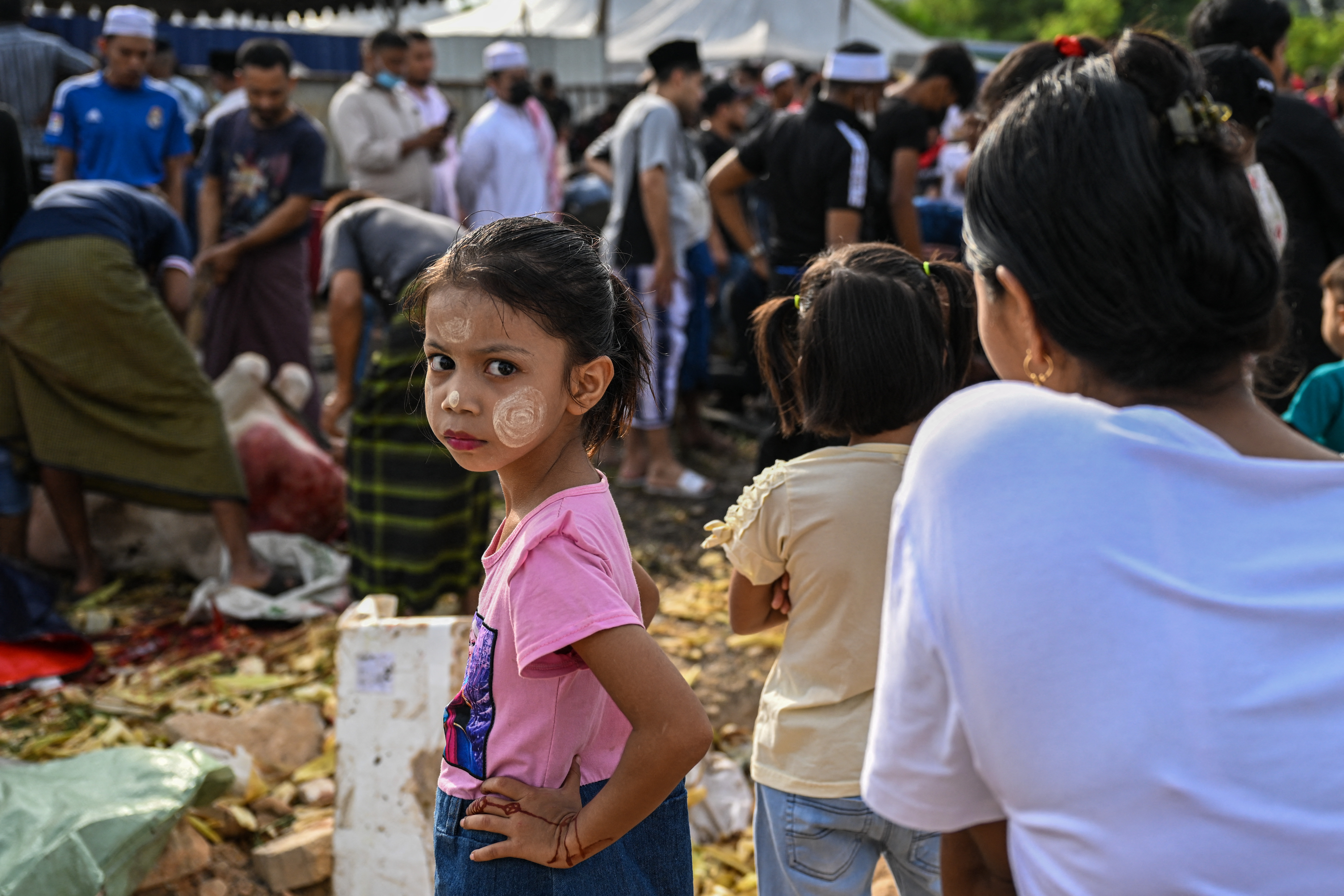 A Rohingya refugee girl living in Malaysia looks on as other slaughter a cow during the Eid al-Adha festival in Kuala Lumpur