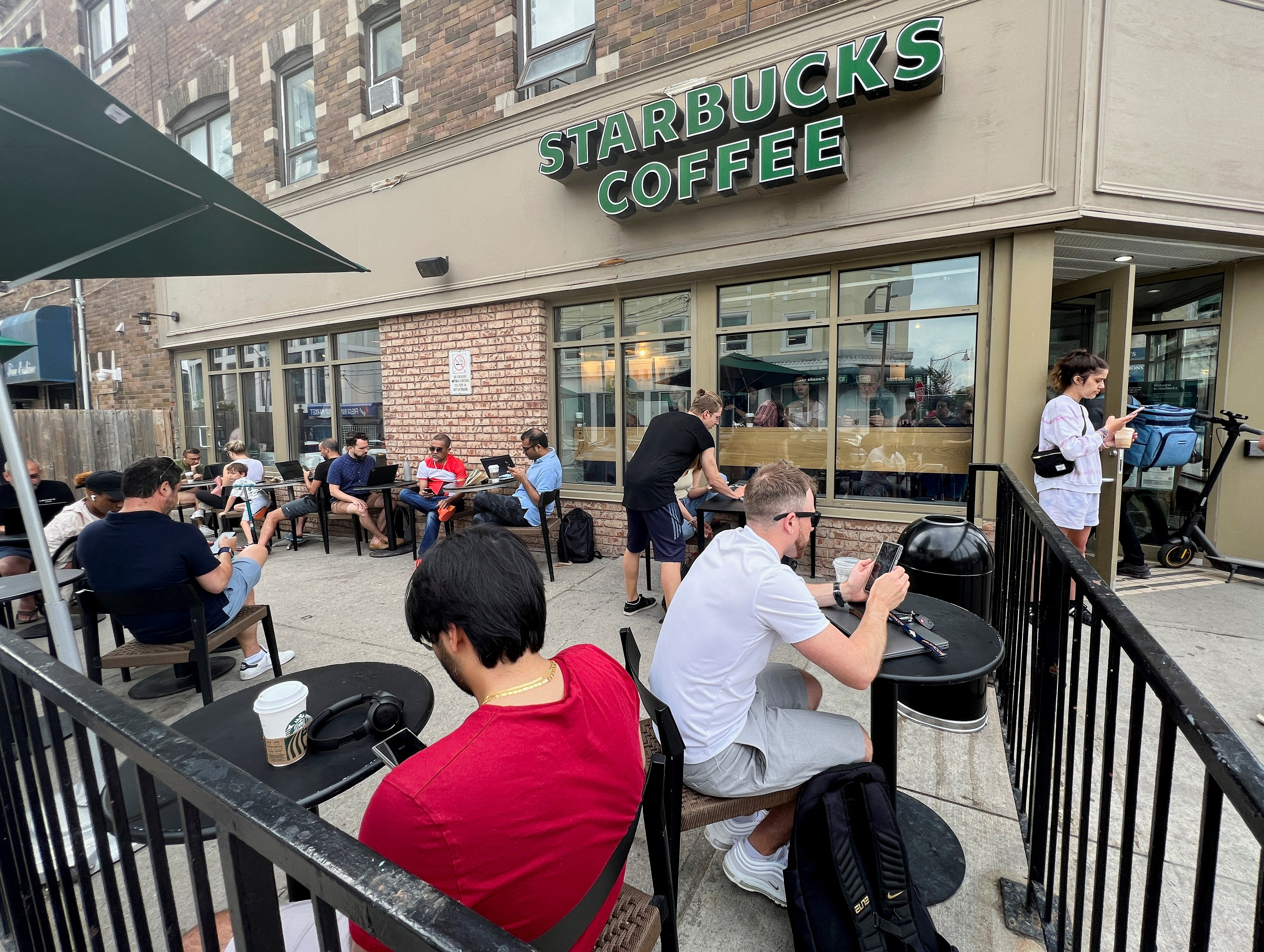 People crowd around a Toronto Starbucks amid a Rogers network outage