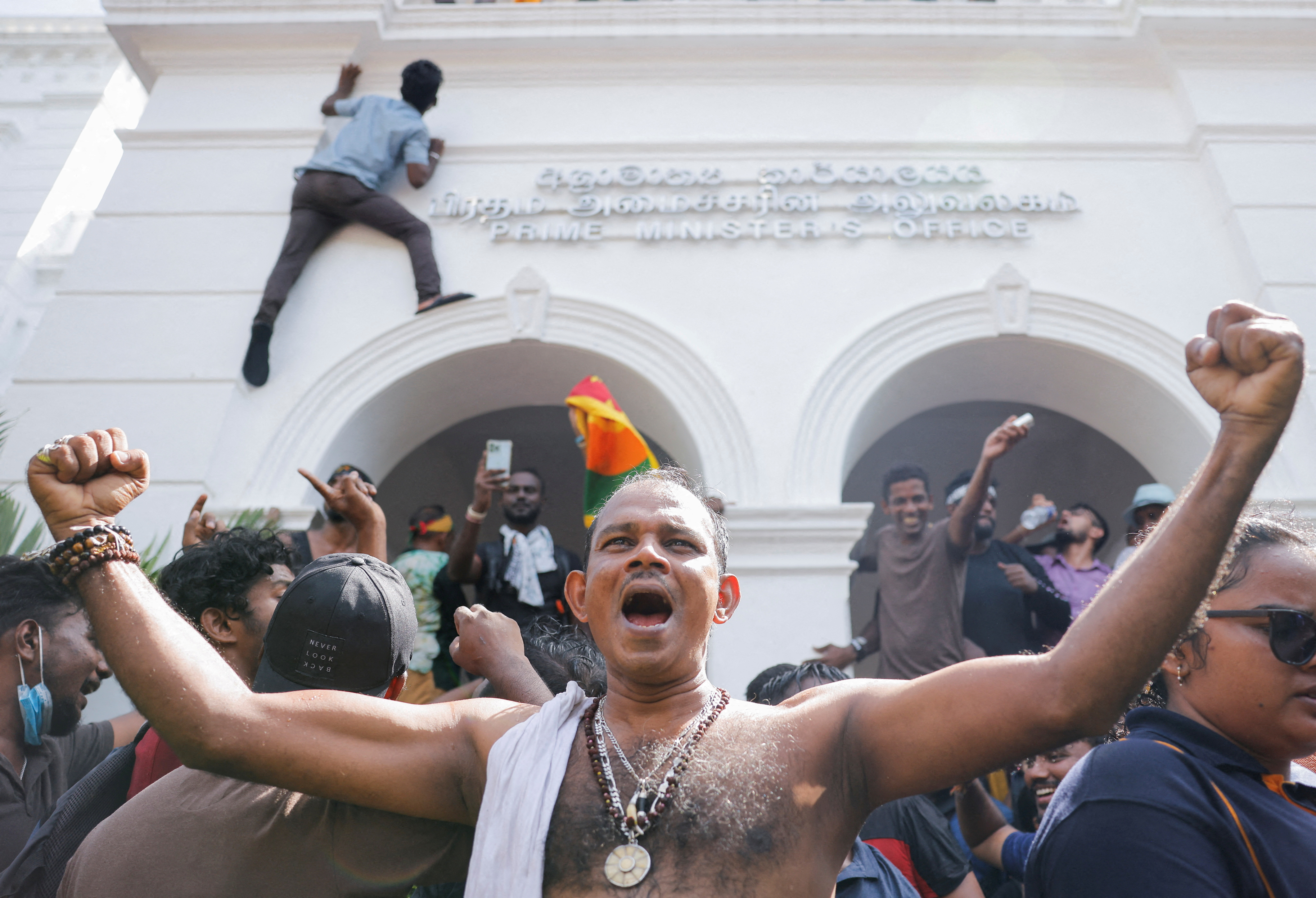 Demonstrators celebrate after they entered into Sri Lankan Prime Minister Ranil Wickremasinghe's office