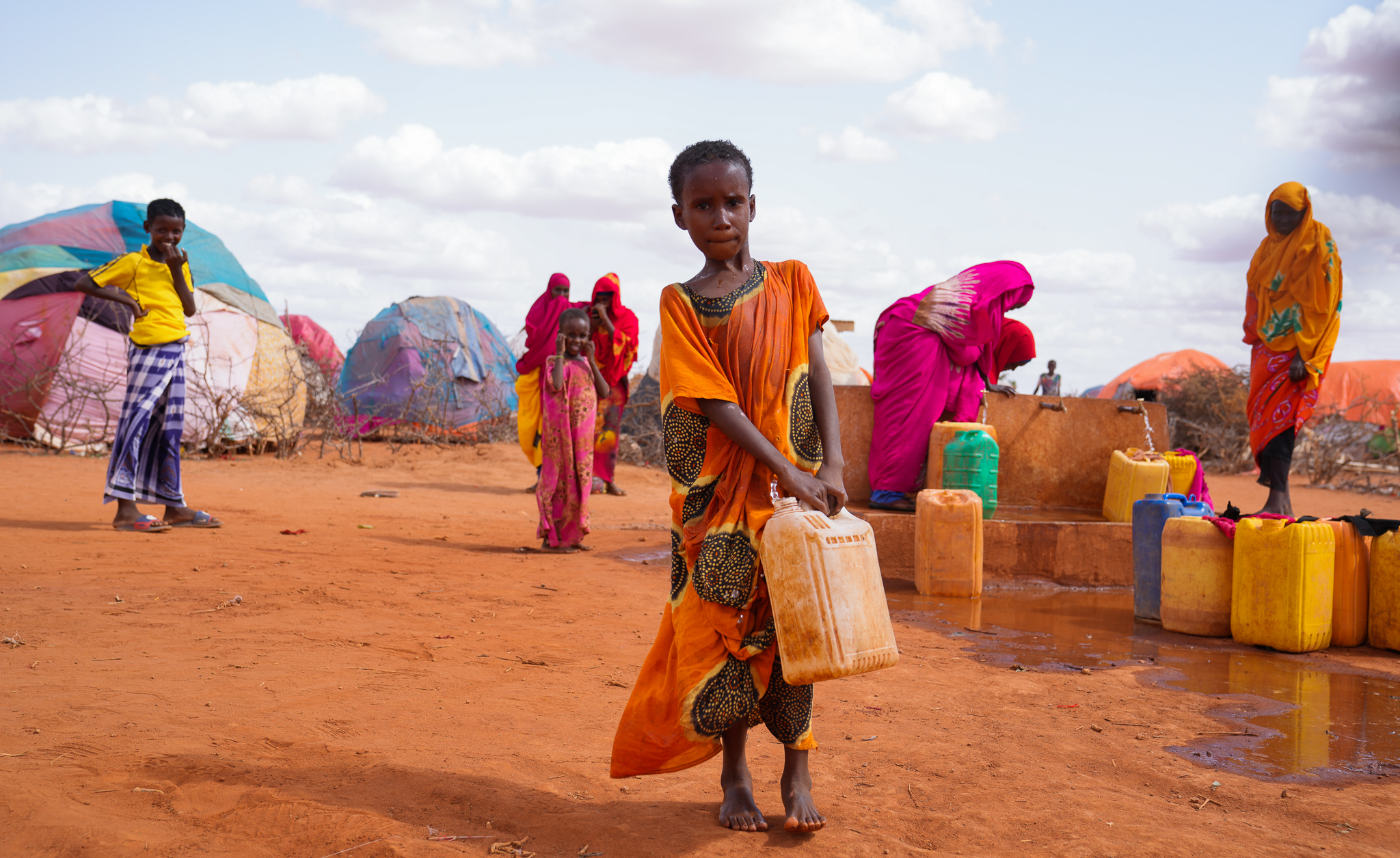 10-year-old Hibo carries water in a jerrycan to her temporary house at Kaharey IDP camp in Dollow, Somalia.